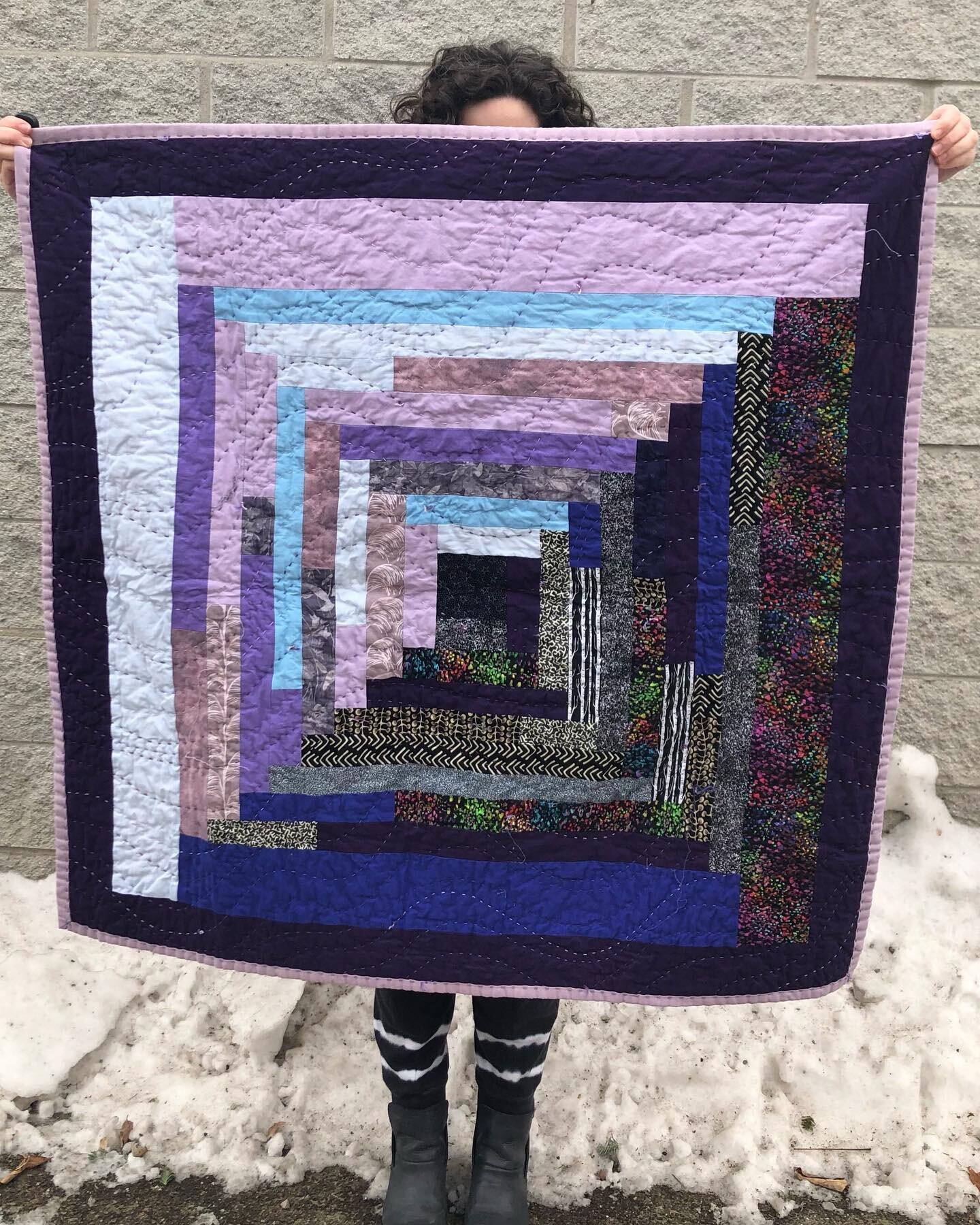 Log cabin in the front, hand quilted party in the back. 💜🍑
.
.
.
.
[ID: Image 1: A log cabin style baby quilt. Emma is holding up the quilt but you can only see her forehead poking out at the top and legs poking out at the bottom. Image 2: The back