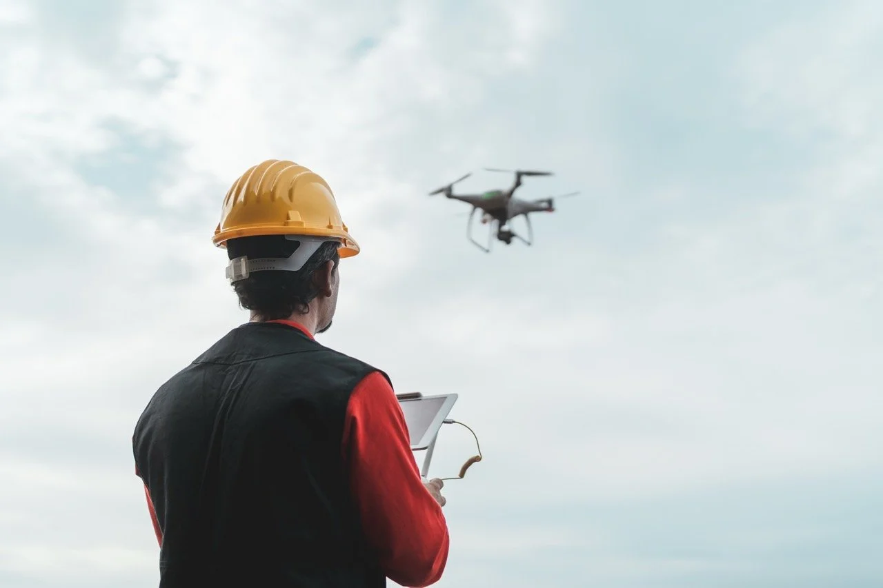 Man in a hardhat flying a drone
