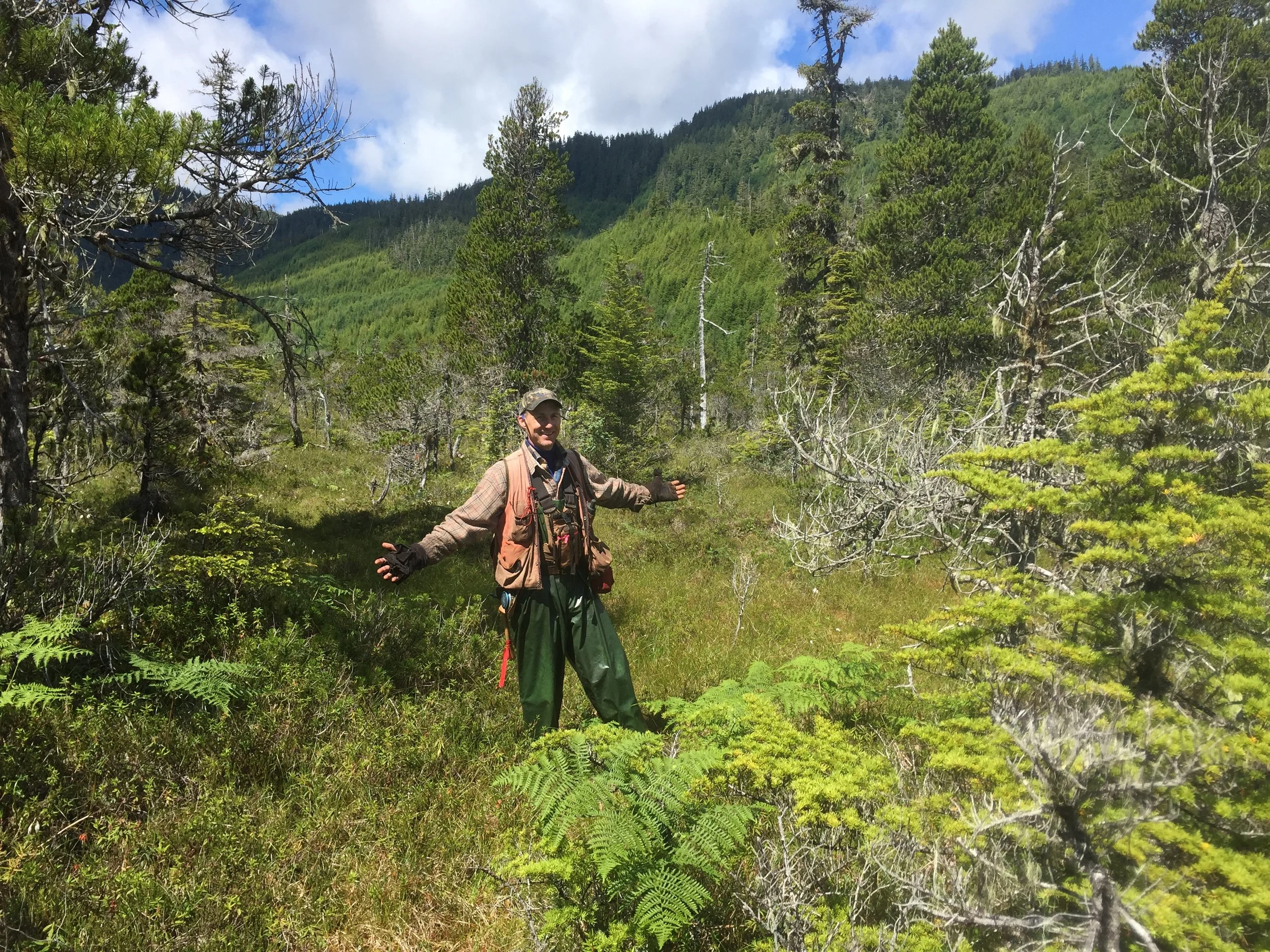 Person in woods with their arms out