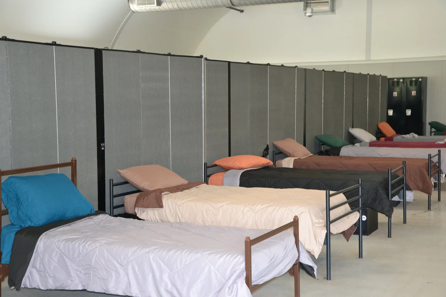 Rows of neatly made shelter beds at an Interfaith Works emergency shelter
