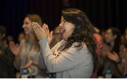 Audience member cheering during a freestyle+ live improv performance.
