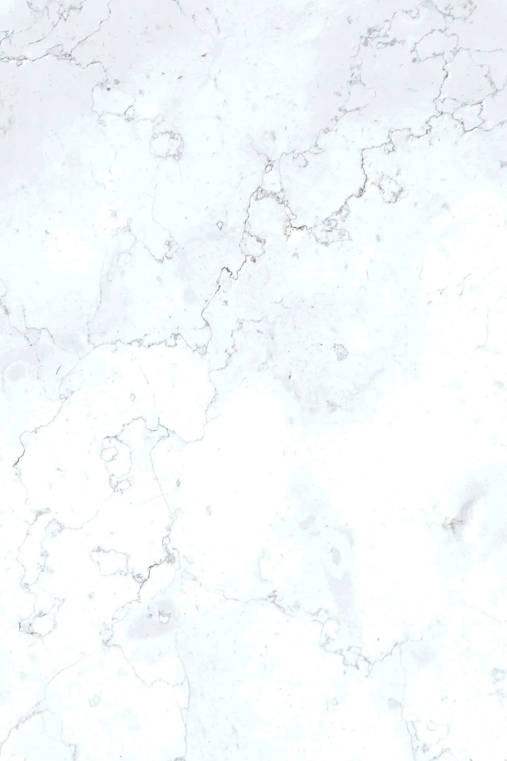 Close-up of a white marble surface with gray veining and cracks.