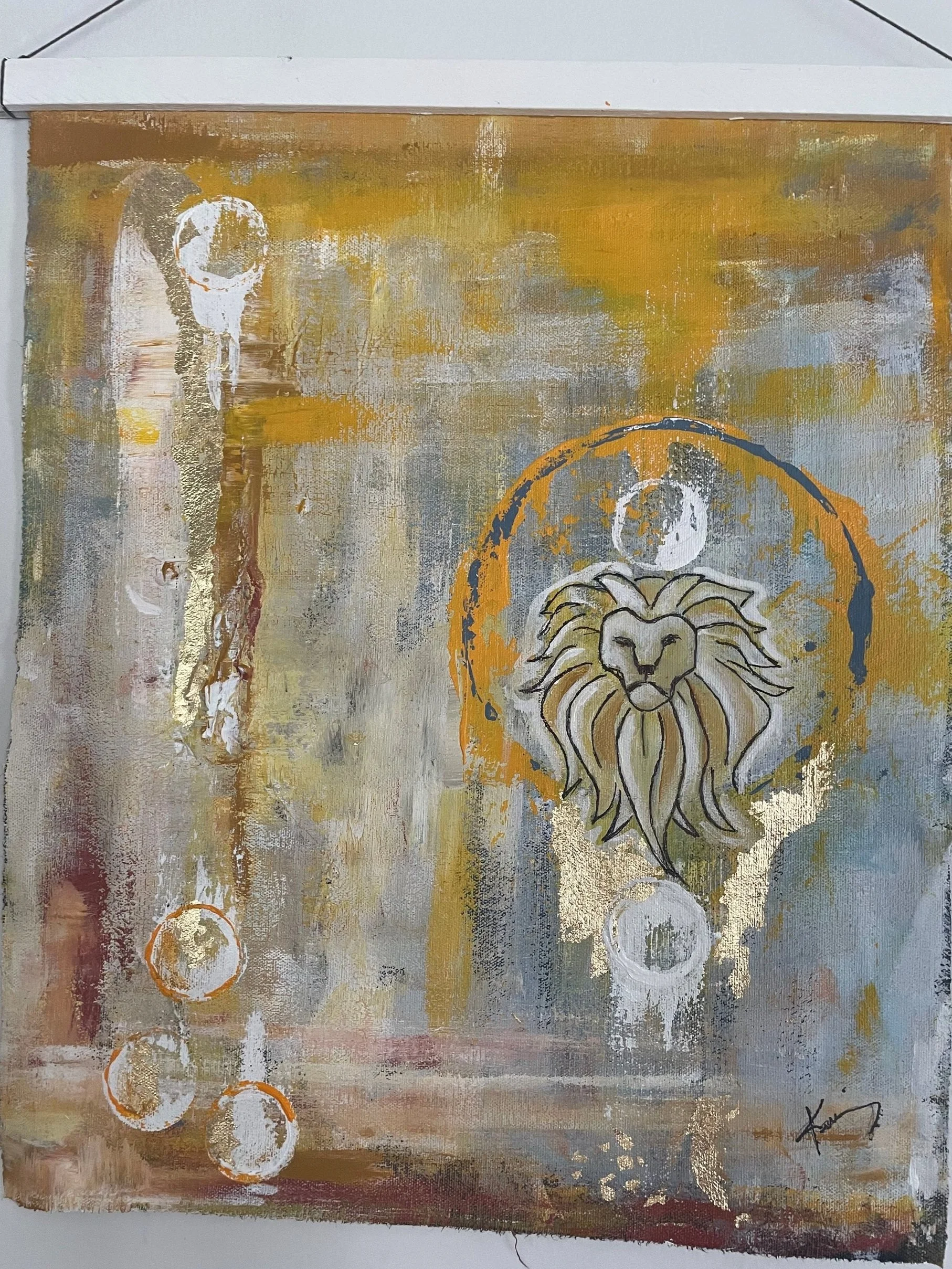 An abstract painting featuring a lion's face surrounded by a halo, with geometric circles and a background of gold, beige, and gray tones.