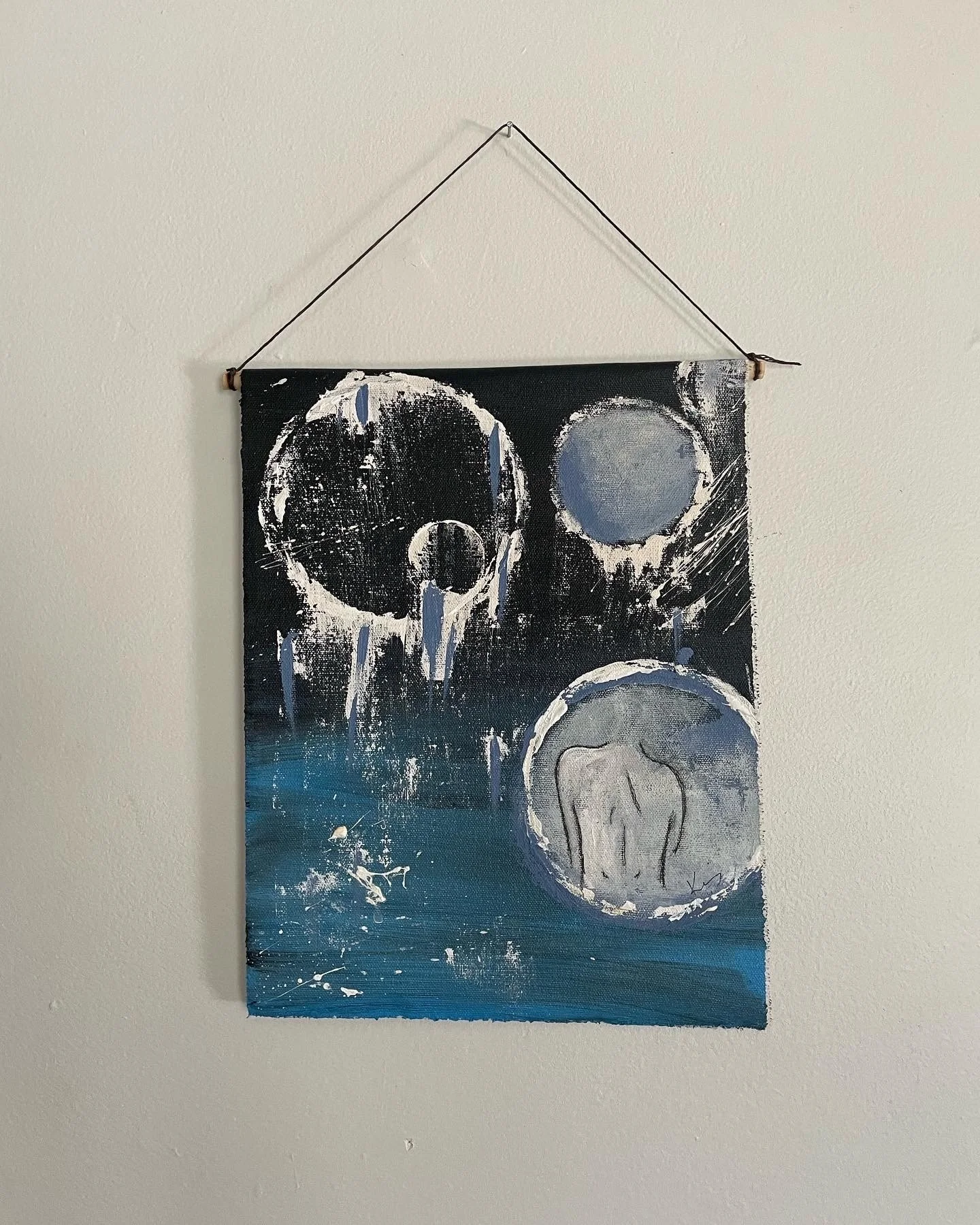 Abstract painting featuring celestial bodies, a crying woman, and splashes of paint on a dark background with blue at the bottom.
