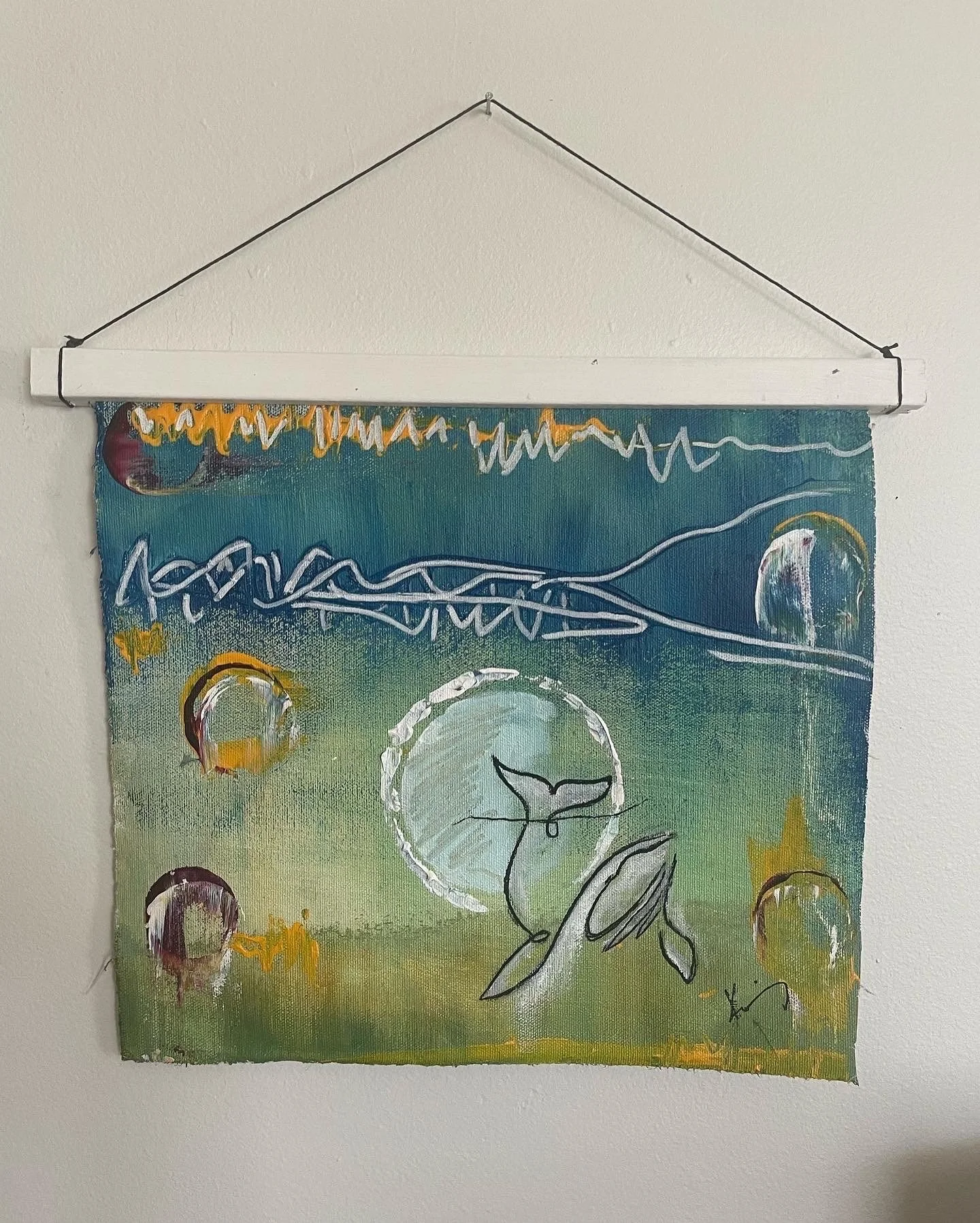Abstract painting with a whale in the center, surrounded by circular patterns and star-like shapes, with a rainbow and sun in the background.