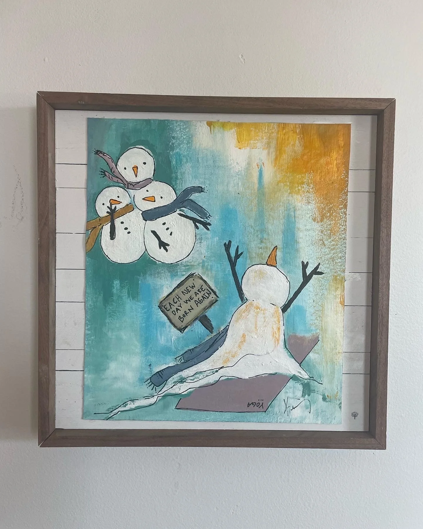A colorful painting of snowmen on a snowy hill, with a sign that reads 'Each new day we are born again' and a sunset in the background.