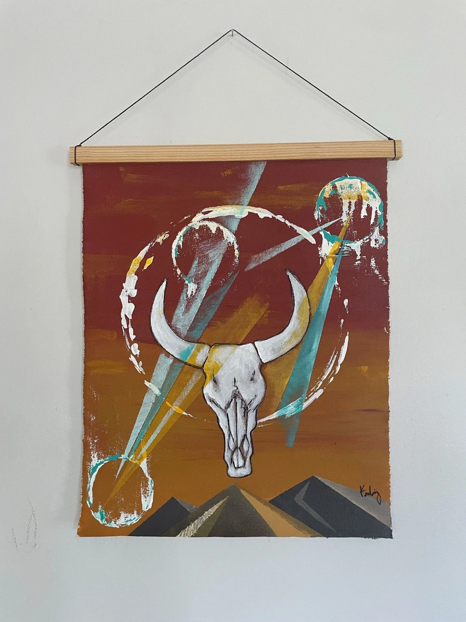 Abstract painting featuring a white animal skull, geometric mountain shapes, and colorful streaks against a reddish-brown background.