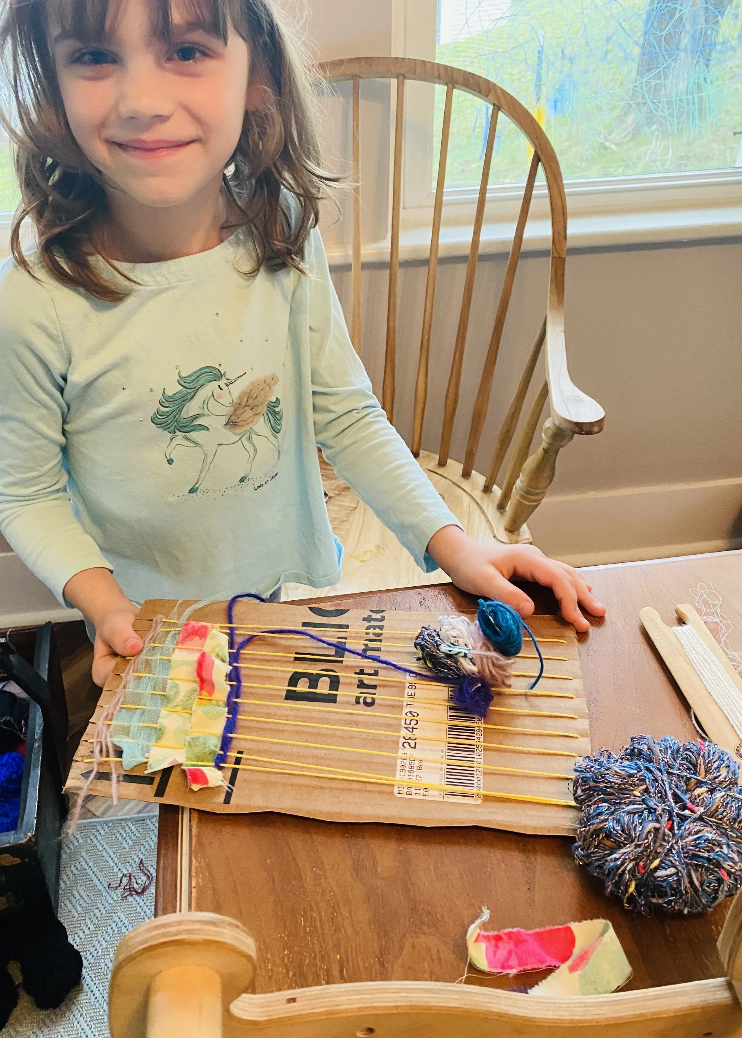 6 year old.  Cardboard loom weaving.