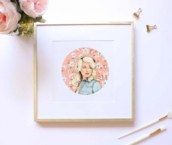 dolly parton vintage style art print in a gold frame with white magnolias and a denim jacket.
