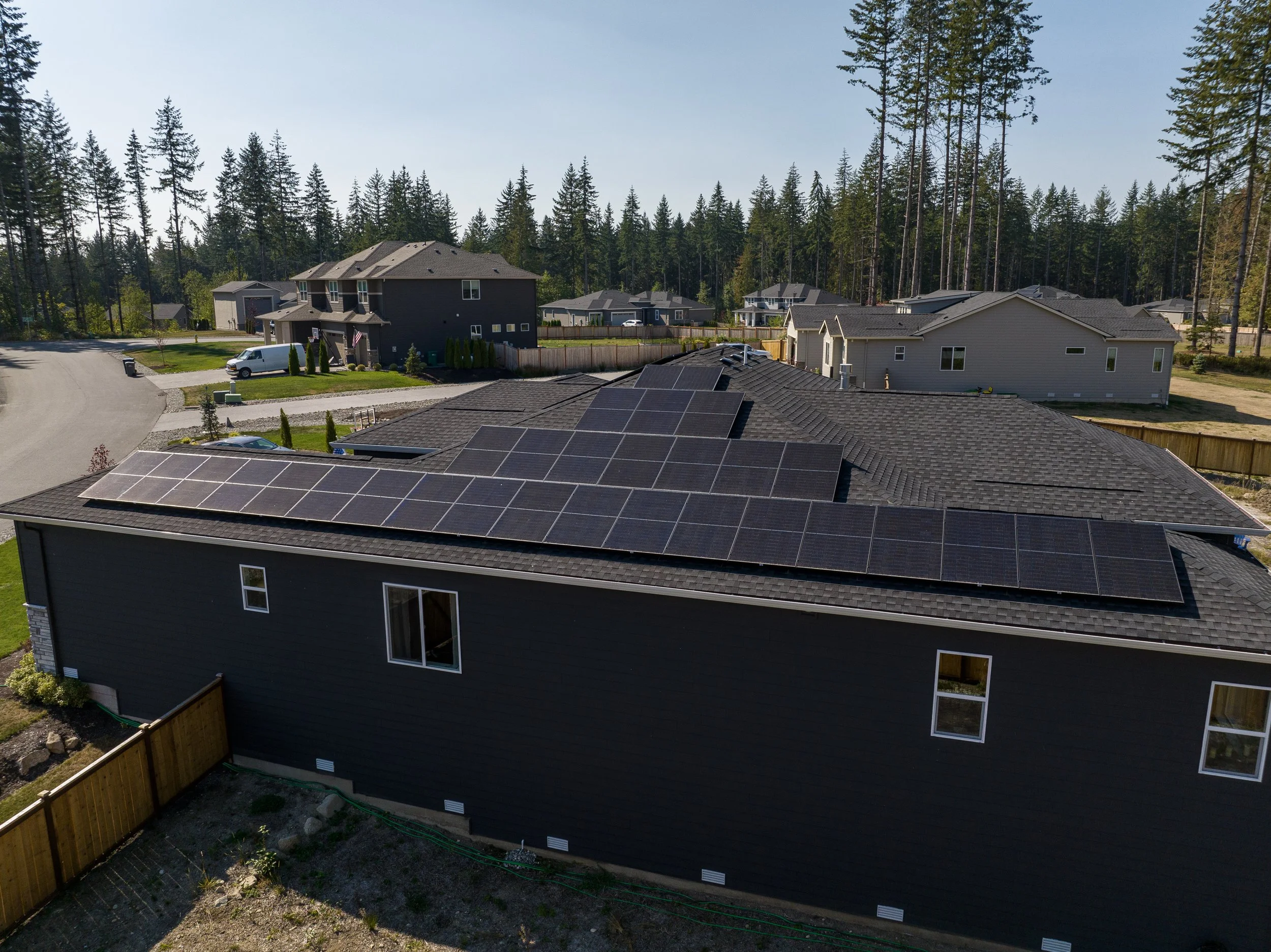 Solar panels installed in Lake Stevens, Washington. Sunny day with evergreen trees.