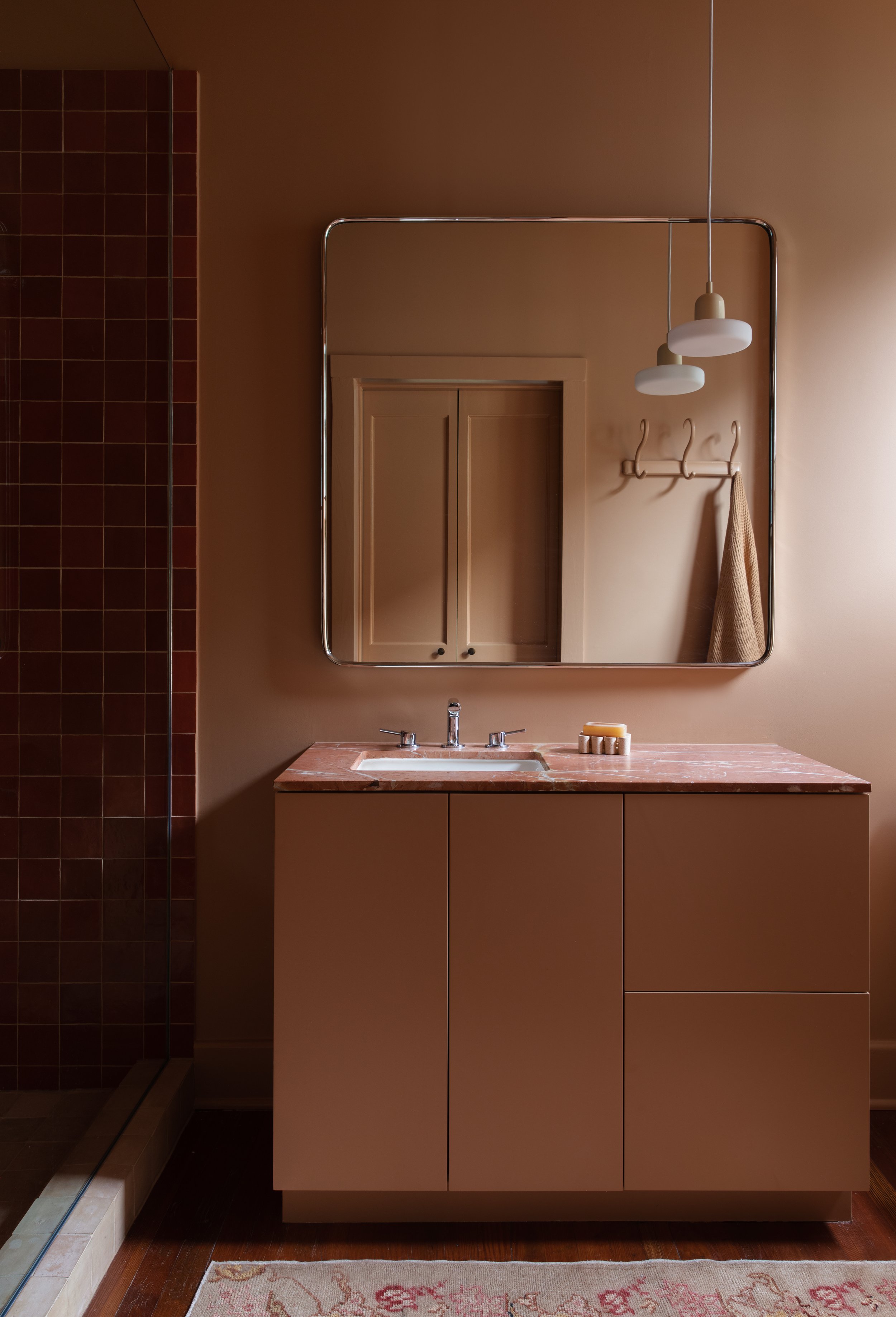  a terracotta peach and dead salmon bathroom with orange and terracotta zellige and in common with lighting interior design houston texas 