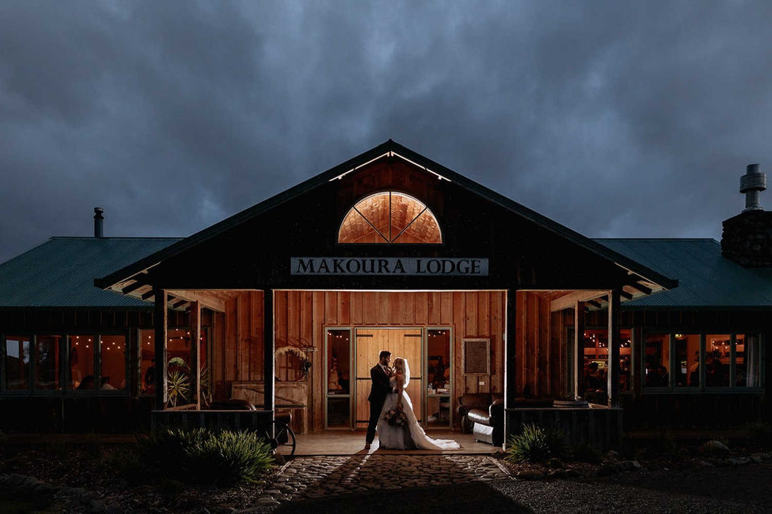 couple at the front of Makoura Lodge getting a wedding photo