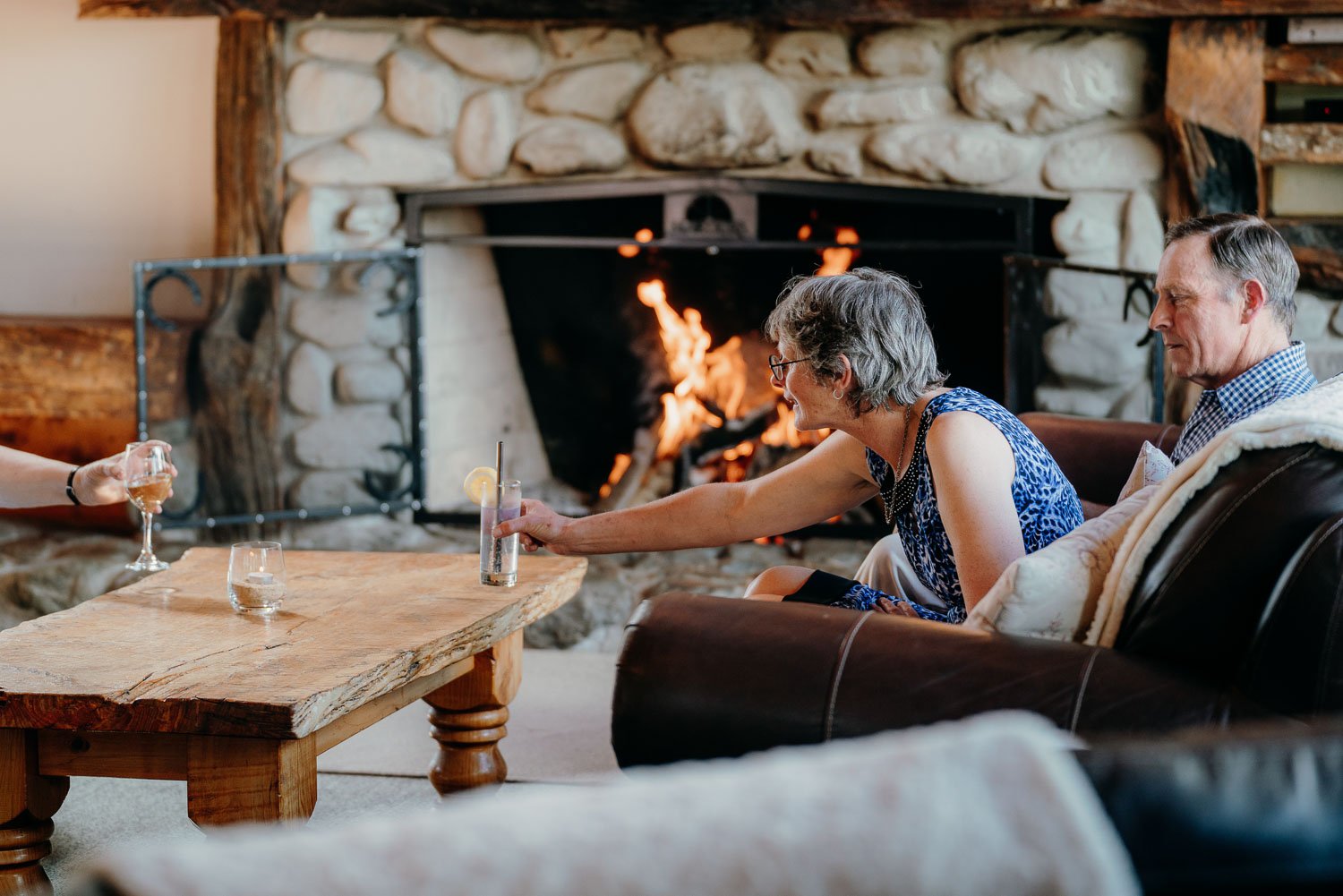 Lady enjoying wine in front of the open fire