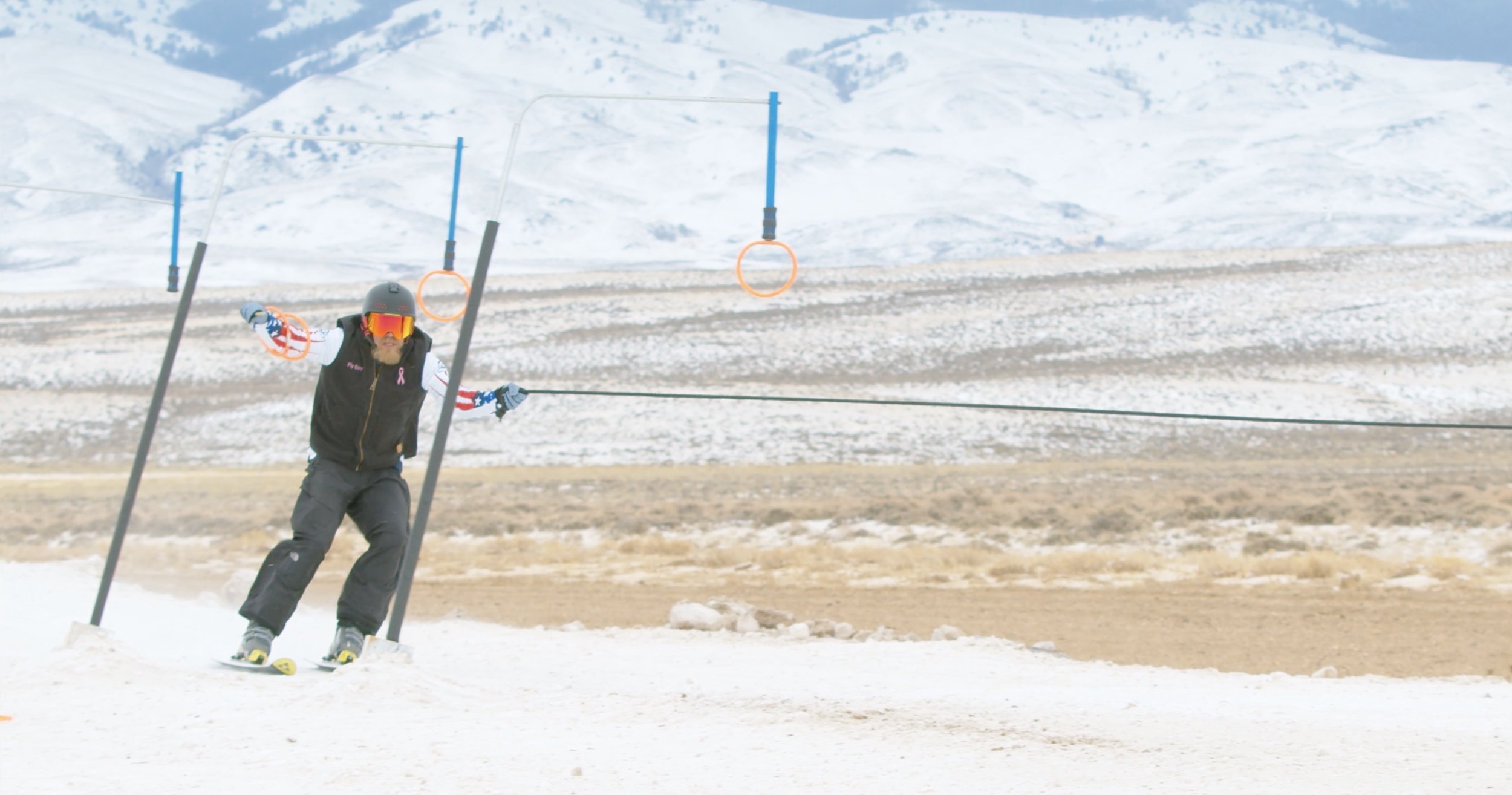 Person skiing downhill holding two rings in snowy landscape