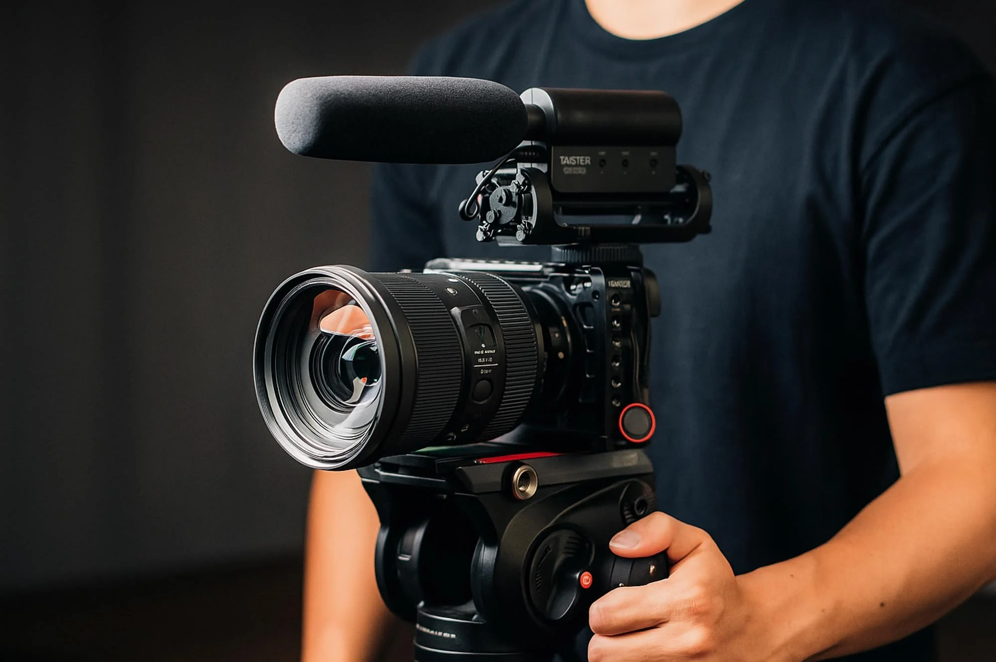 A camera operator holding a professional mobile camera setup with a shotgun microphone, typical for agile or lower-cost Montreal video shoots.