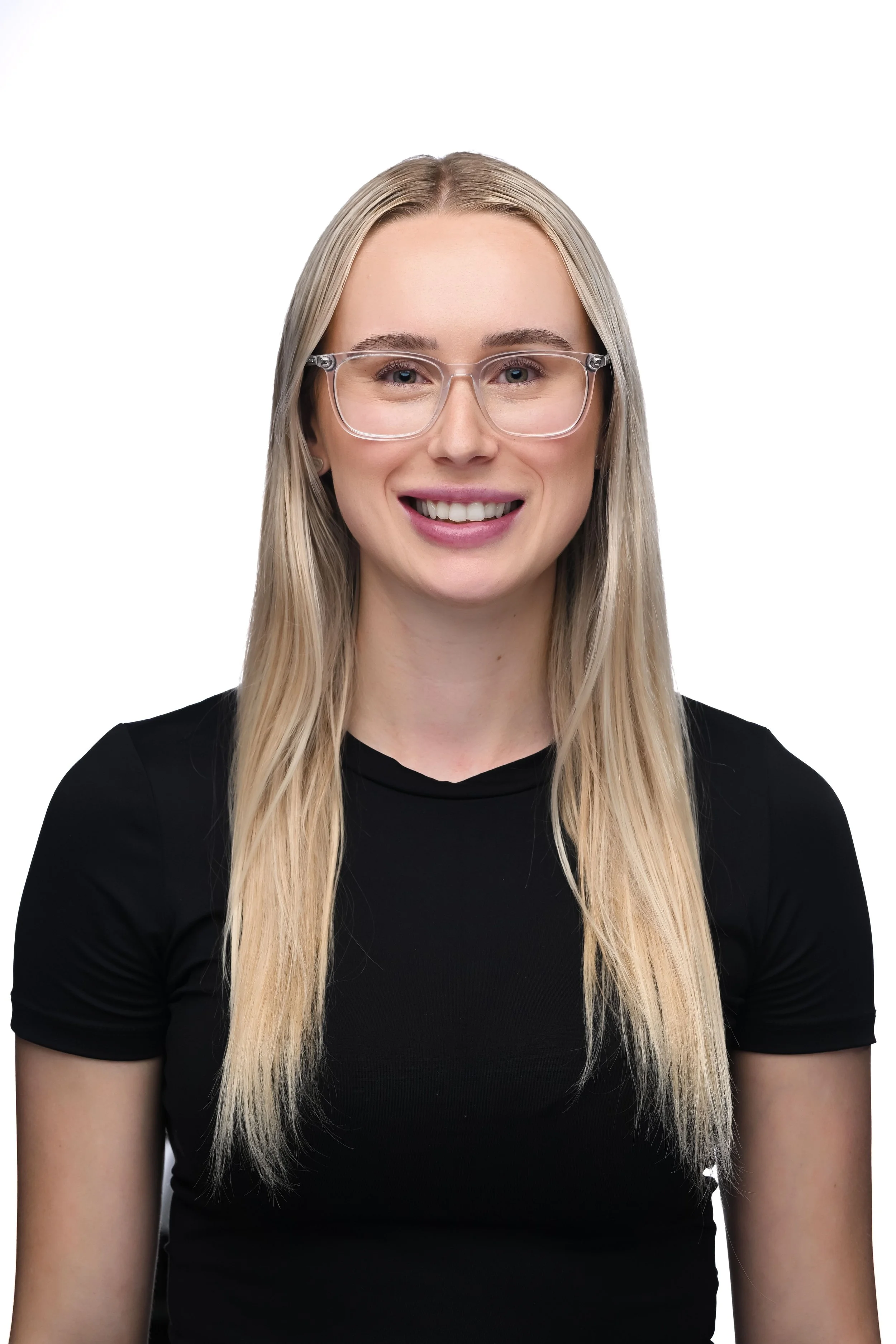 A smiling young woman with long blonde hair, wearing clear glasses and a black shirt, against a white background.