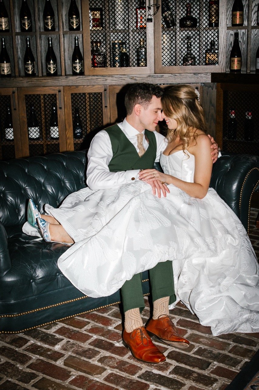 Flash photo of couple sitting on couch together with heads touching in side room of xGoose Island Barrel House