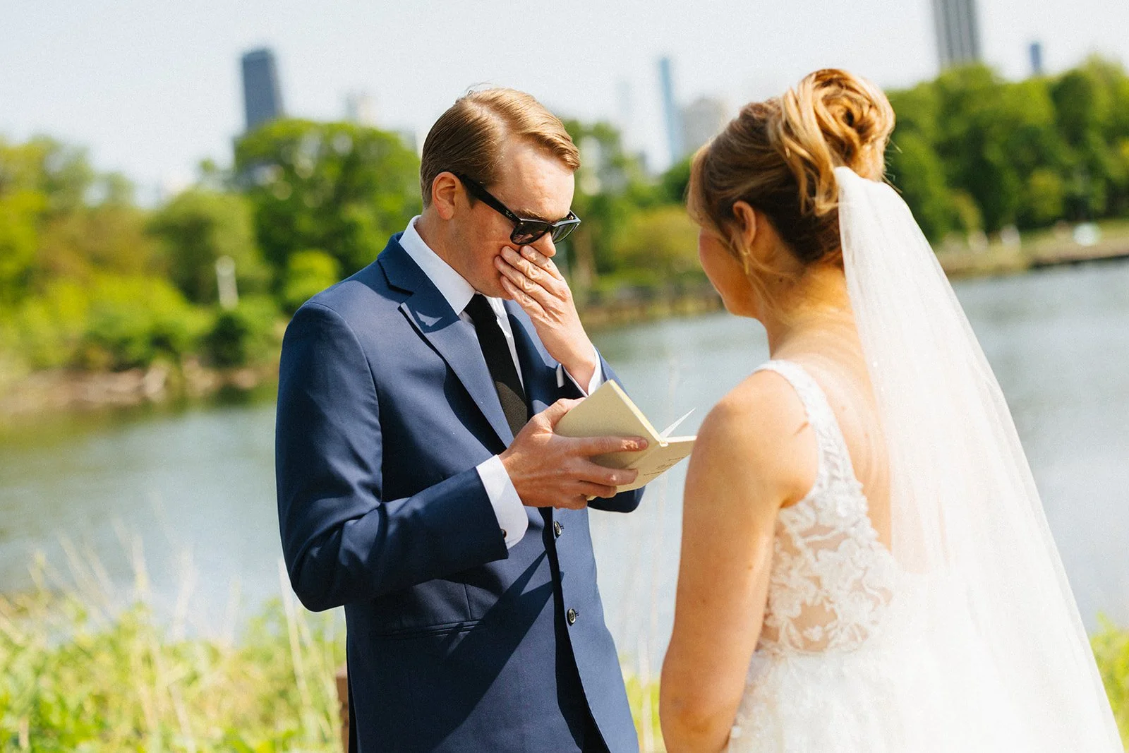 Groom holding face while reading bride his vows in Lincoln Park Zoo in Chicago