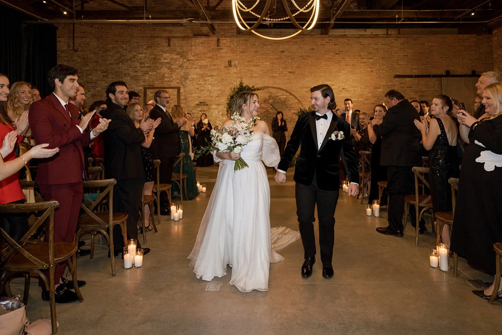 Couple holding hands in aisle of wedding ceremony recessional
