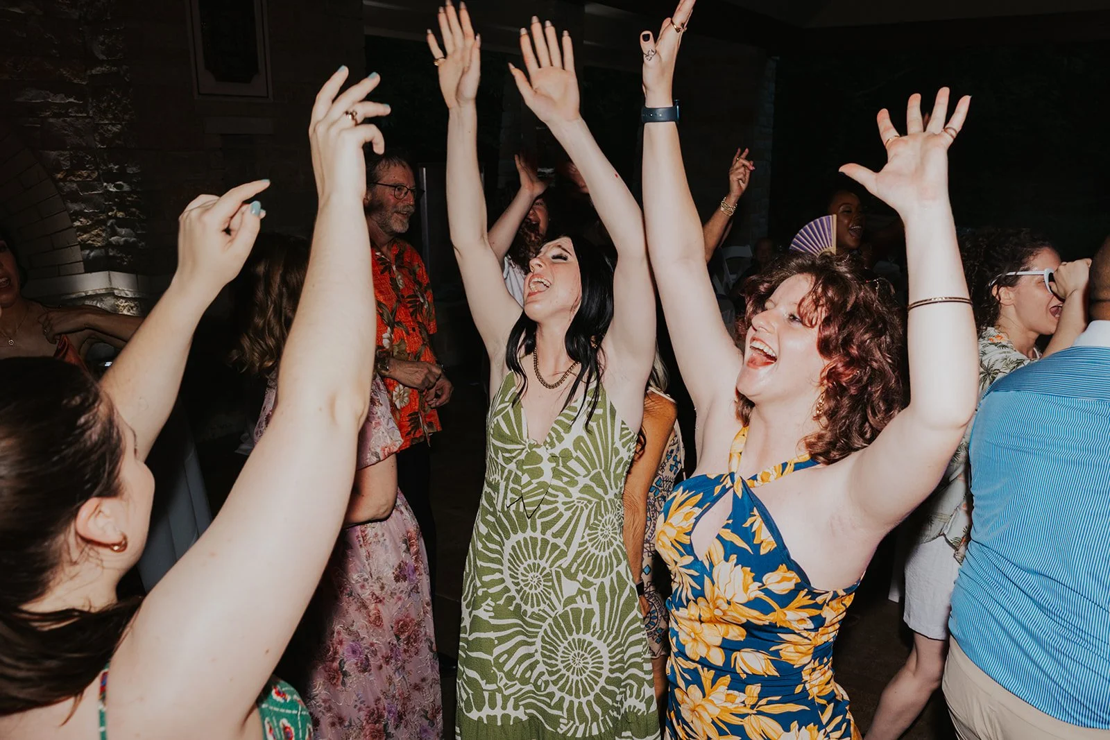 Wedding guests raising hands and singing together