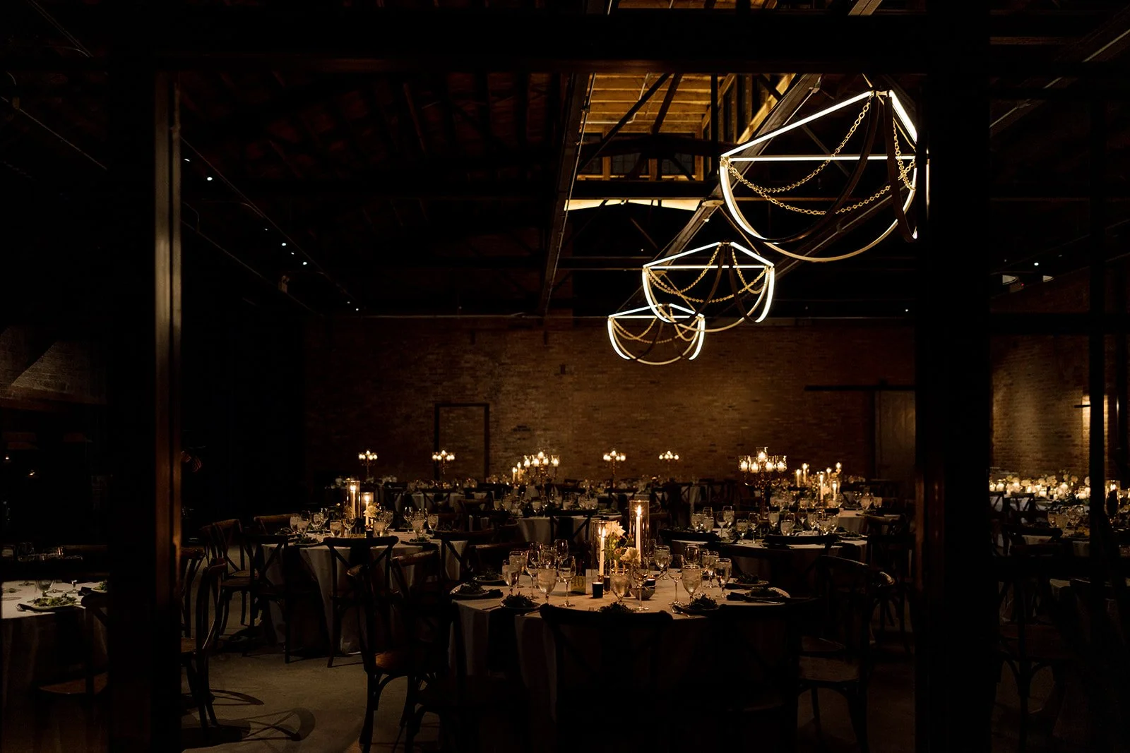 Moody dark lighting with unique lighting and candles with tables and chairs