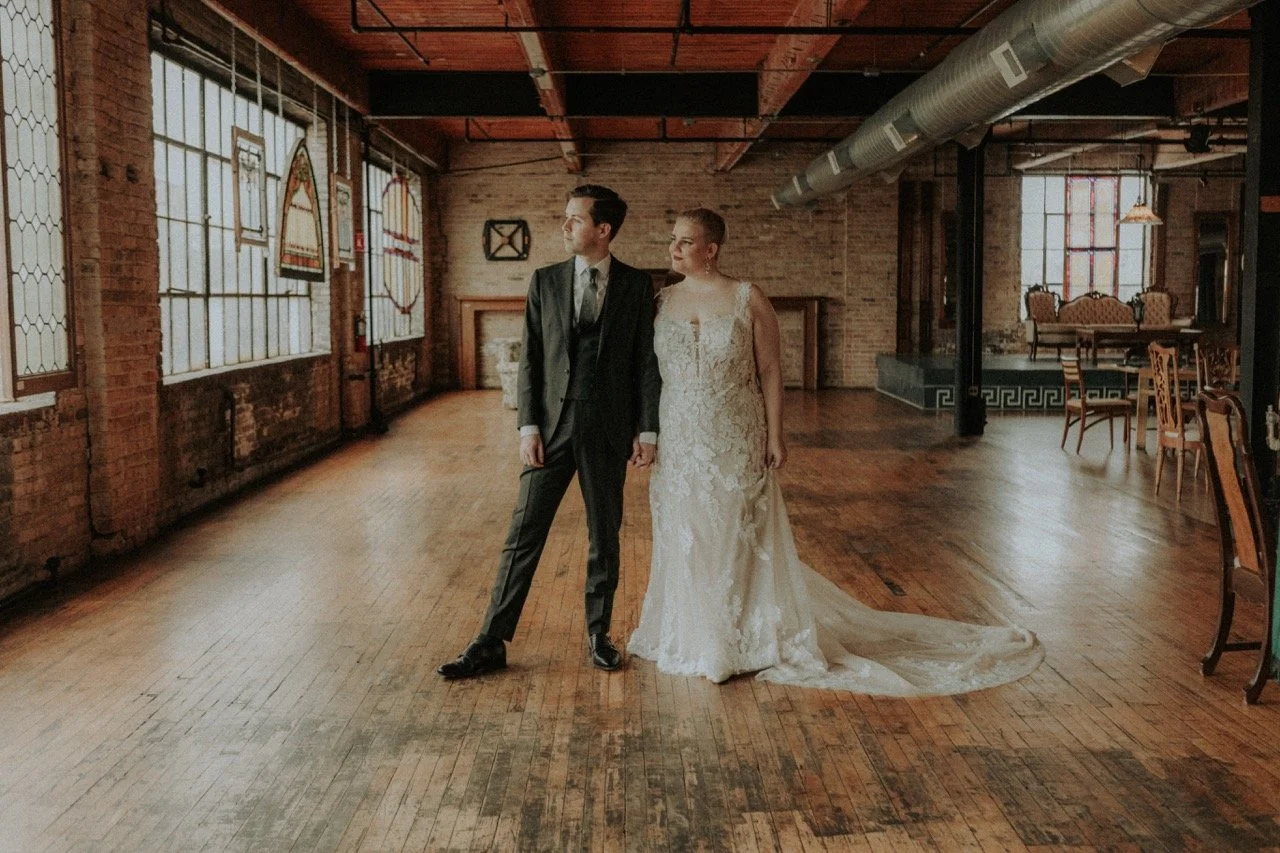 Bride and Groom standing in empty area looking out window together at Salvage One