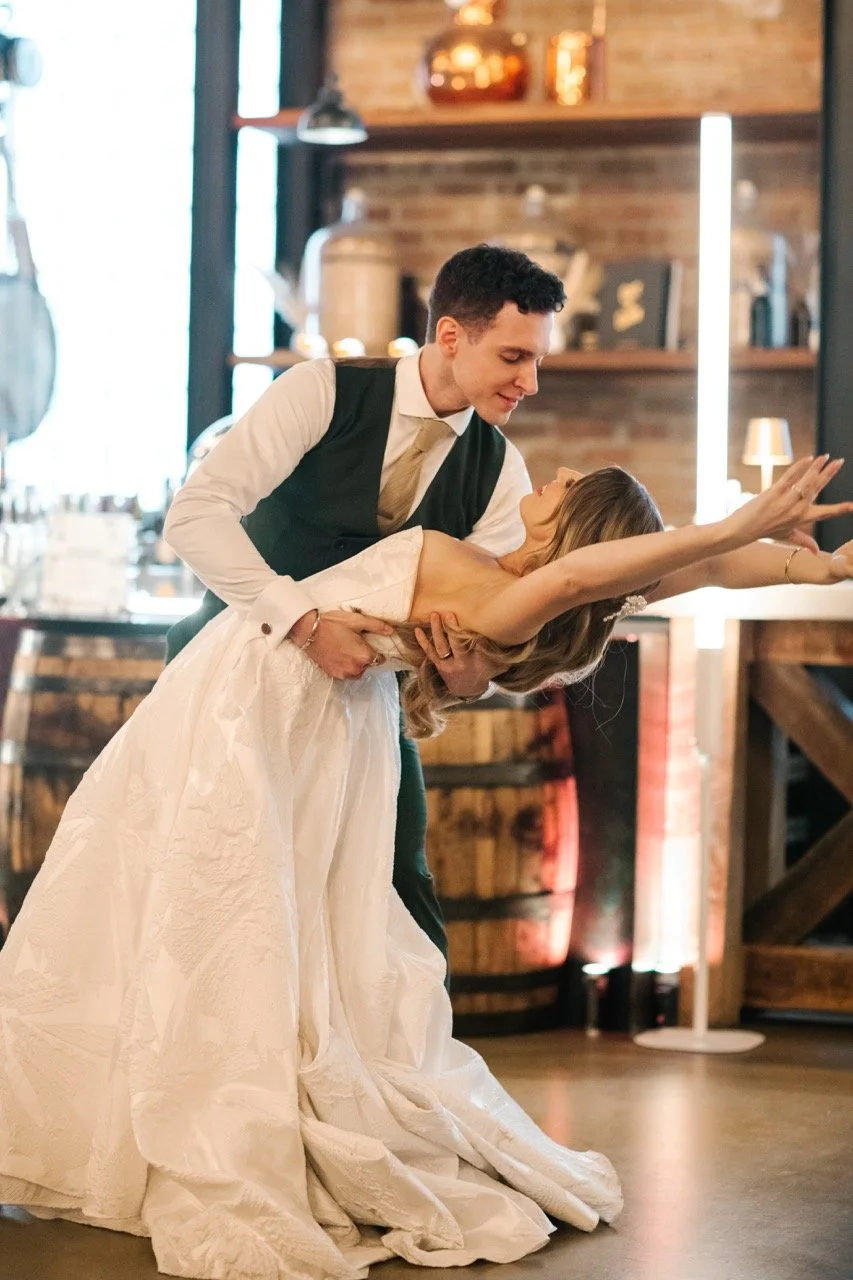 Dip at first dance with bride's arms above her head romantically