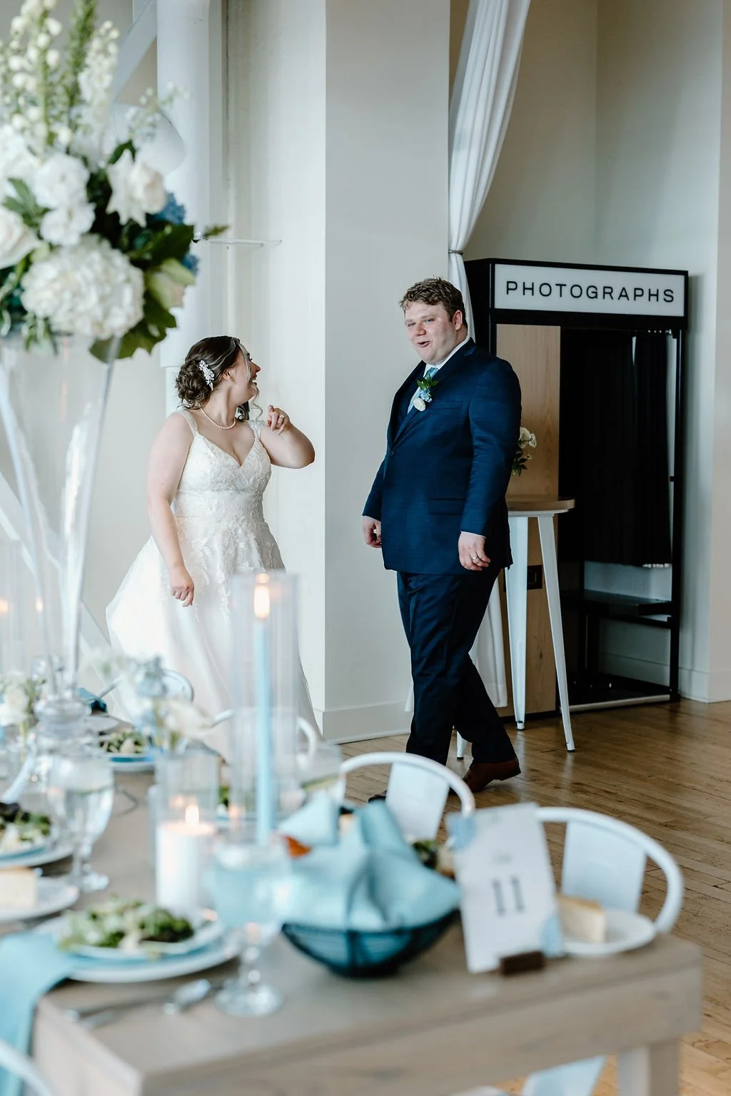Bride looking at groom and smiling while pointing at the reception setup with groom looking surprised