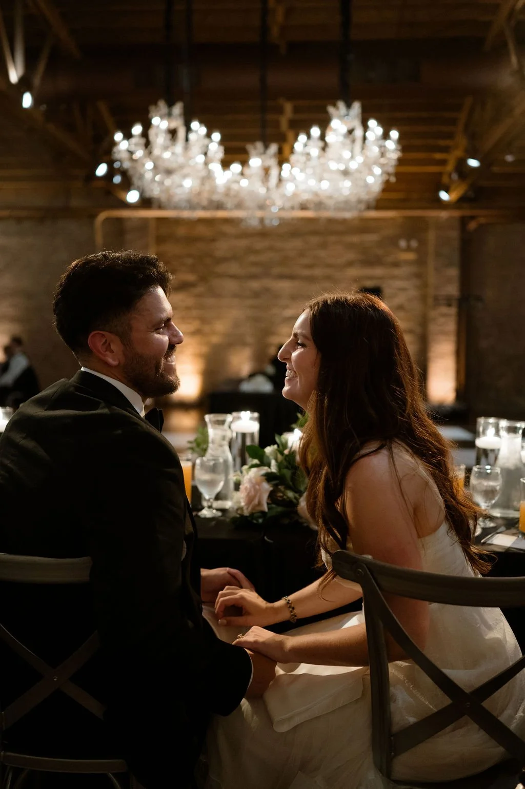 Chicago couple sitting at head table smiling at each other