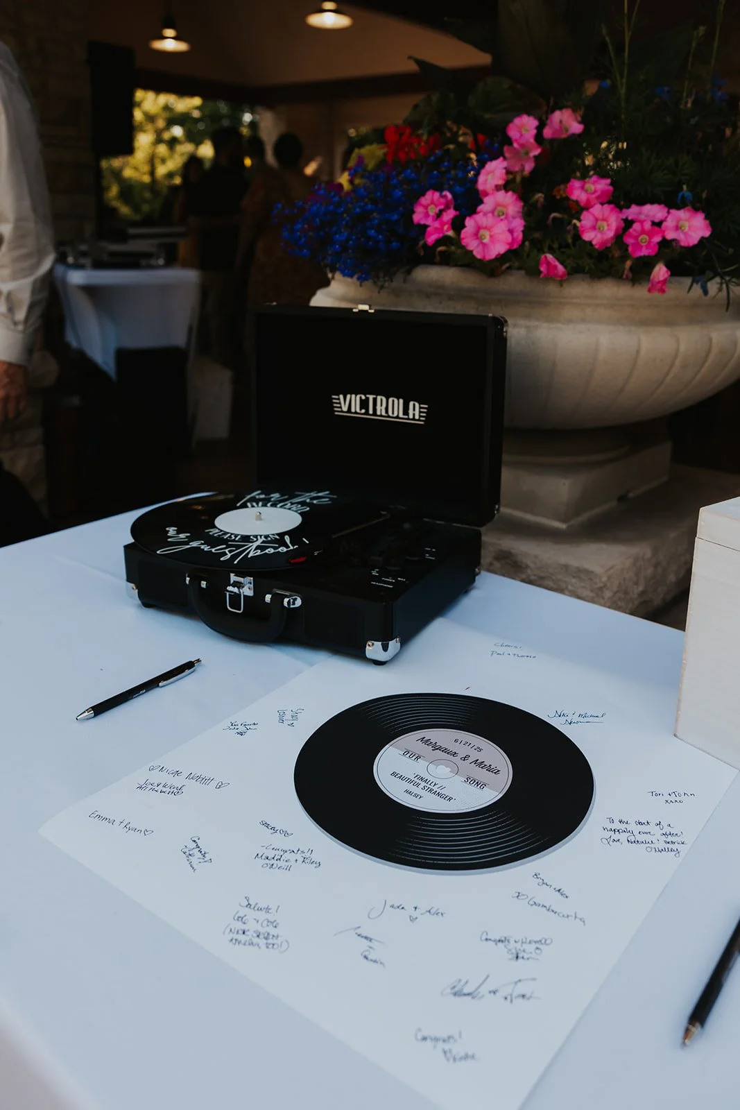 record player on table with record on a sheet of paper for guests to sign as the guest book
