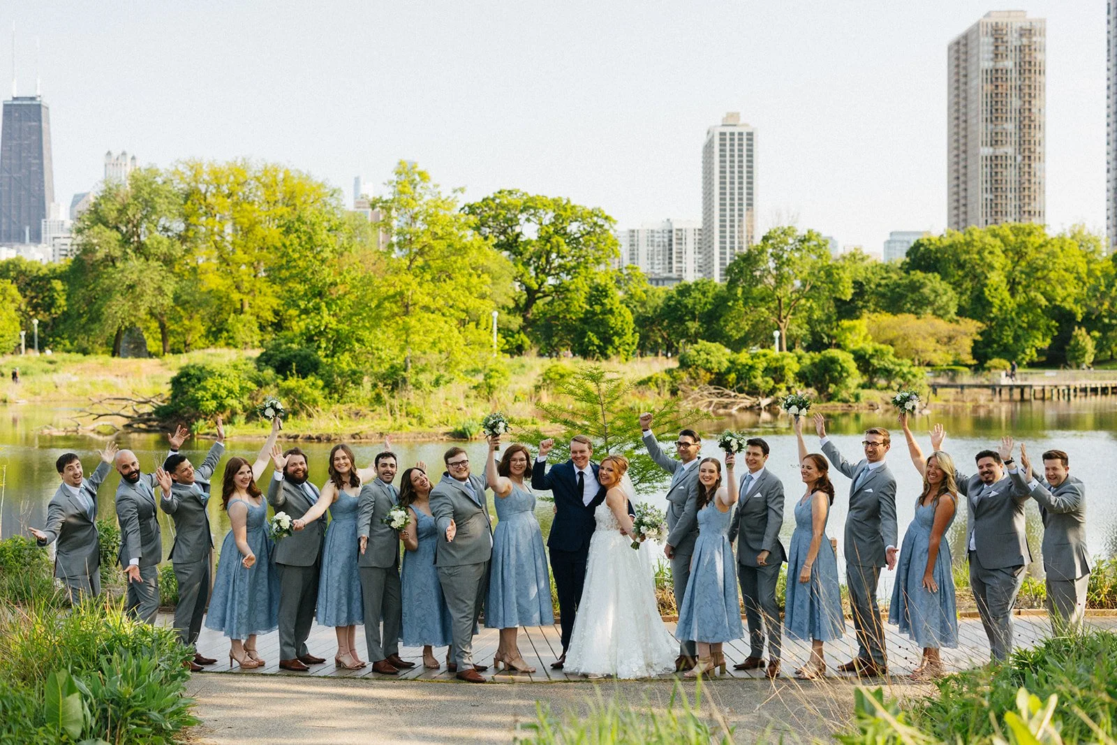 Bride, groom, and staggered wedding party all cheering after wedding ceremony at People's Gas Pavilion The Honeycomb in Chicago