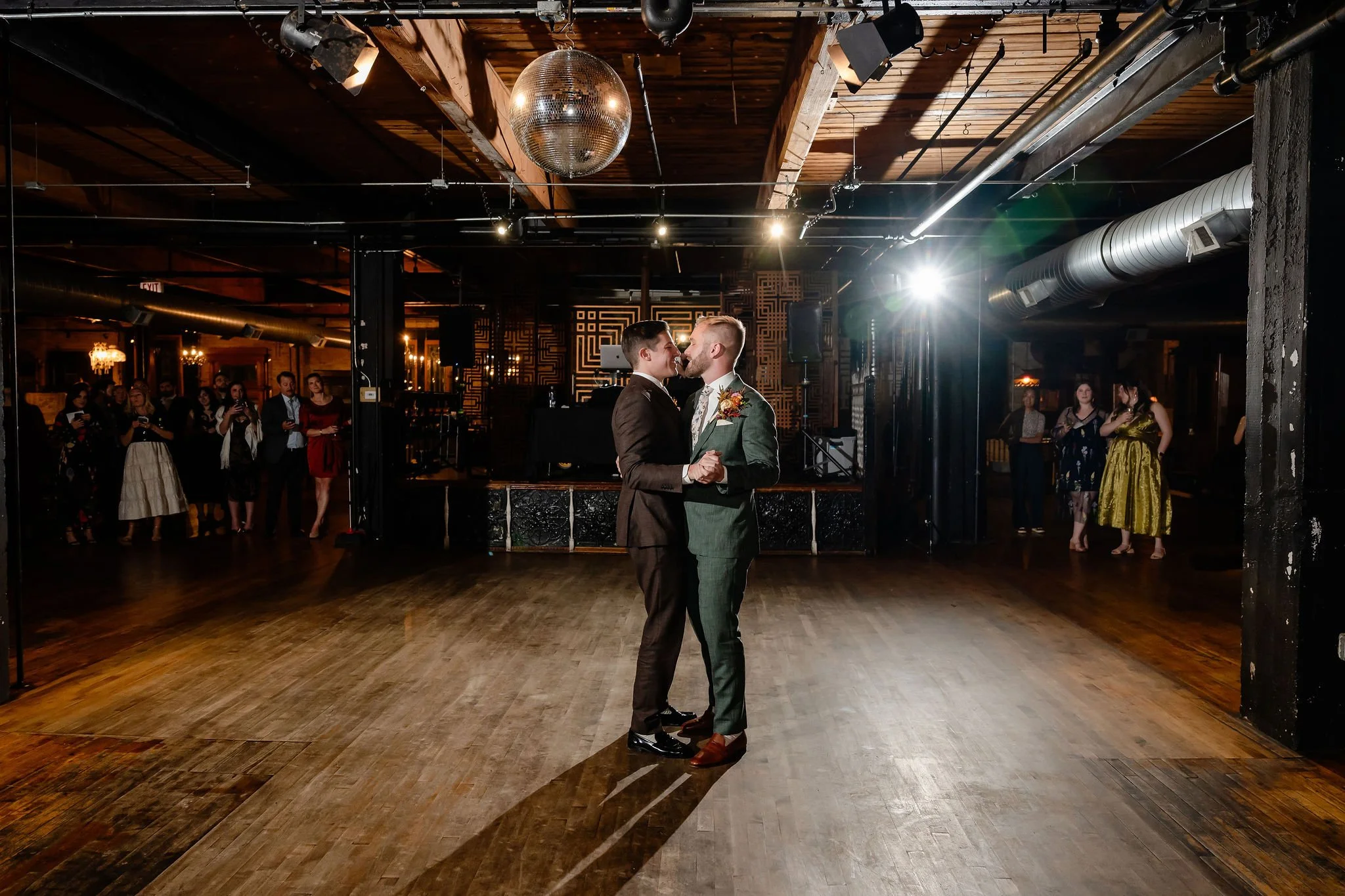 unique fun wedding on dance floor at reception with disco ball above them