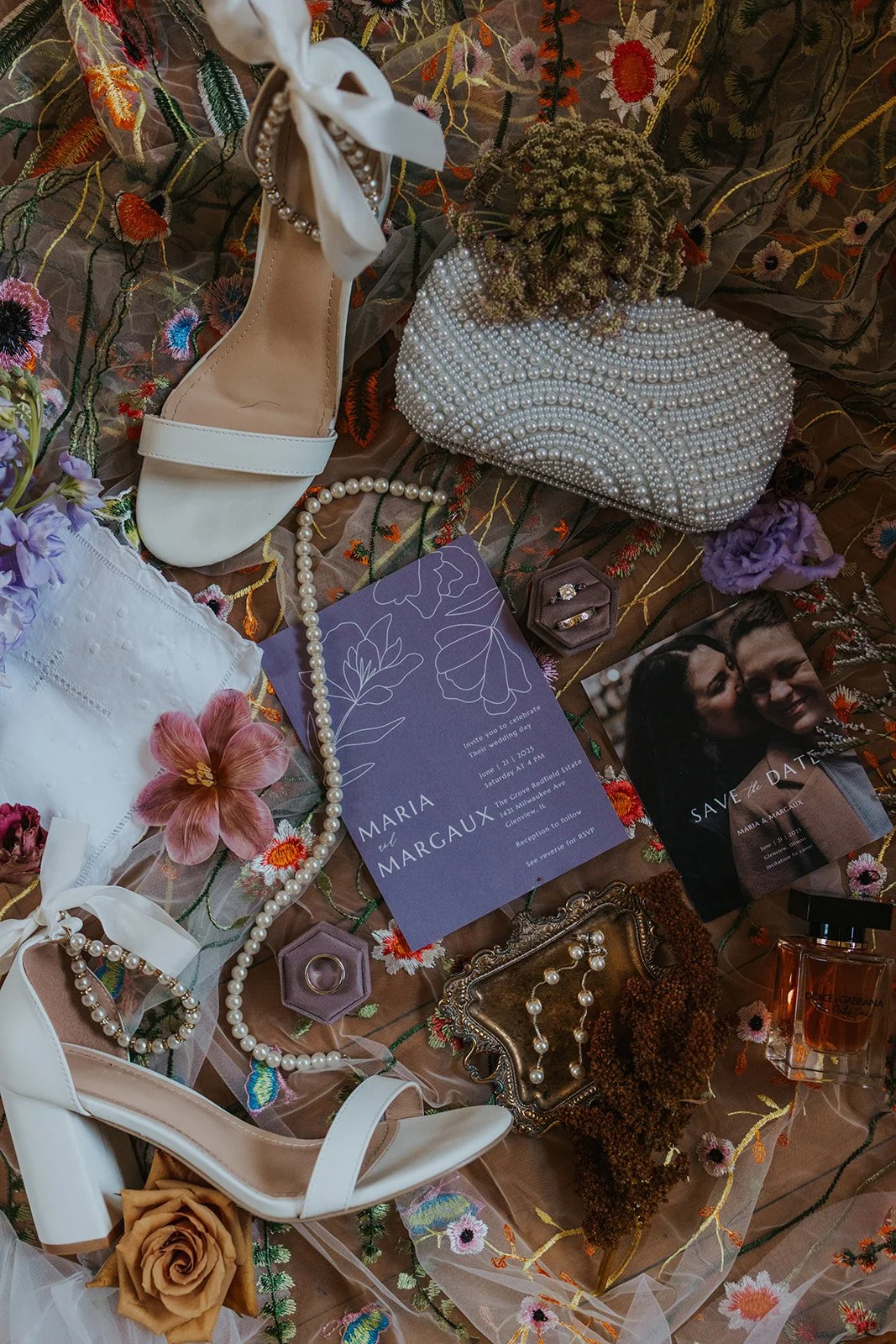 funky cool details flatlay with shoes, embroidered veil, invitation, jewelry all laid on the veil
