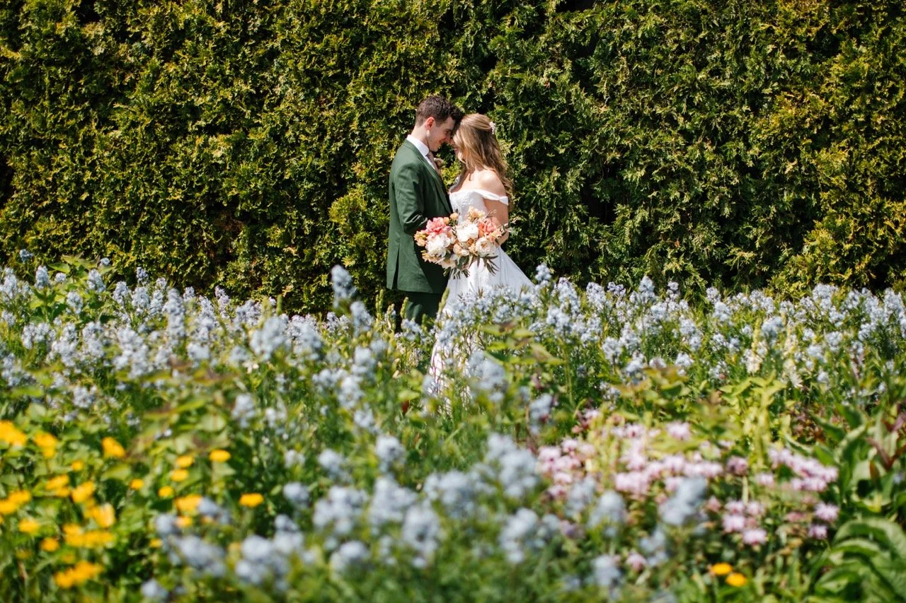 Bride and groom foreheads touching with flower garden in foreground for Chicago wedding photos