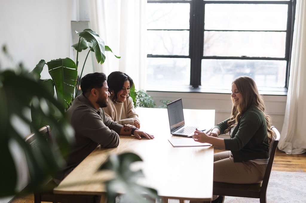 wedding coordinator meeting with couple at table with computer