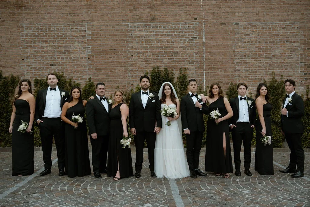 Bride, groom, and wedding party members looking at camera seriously