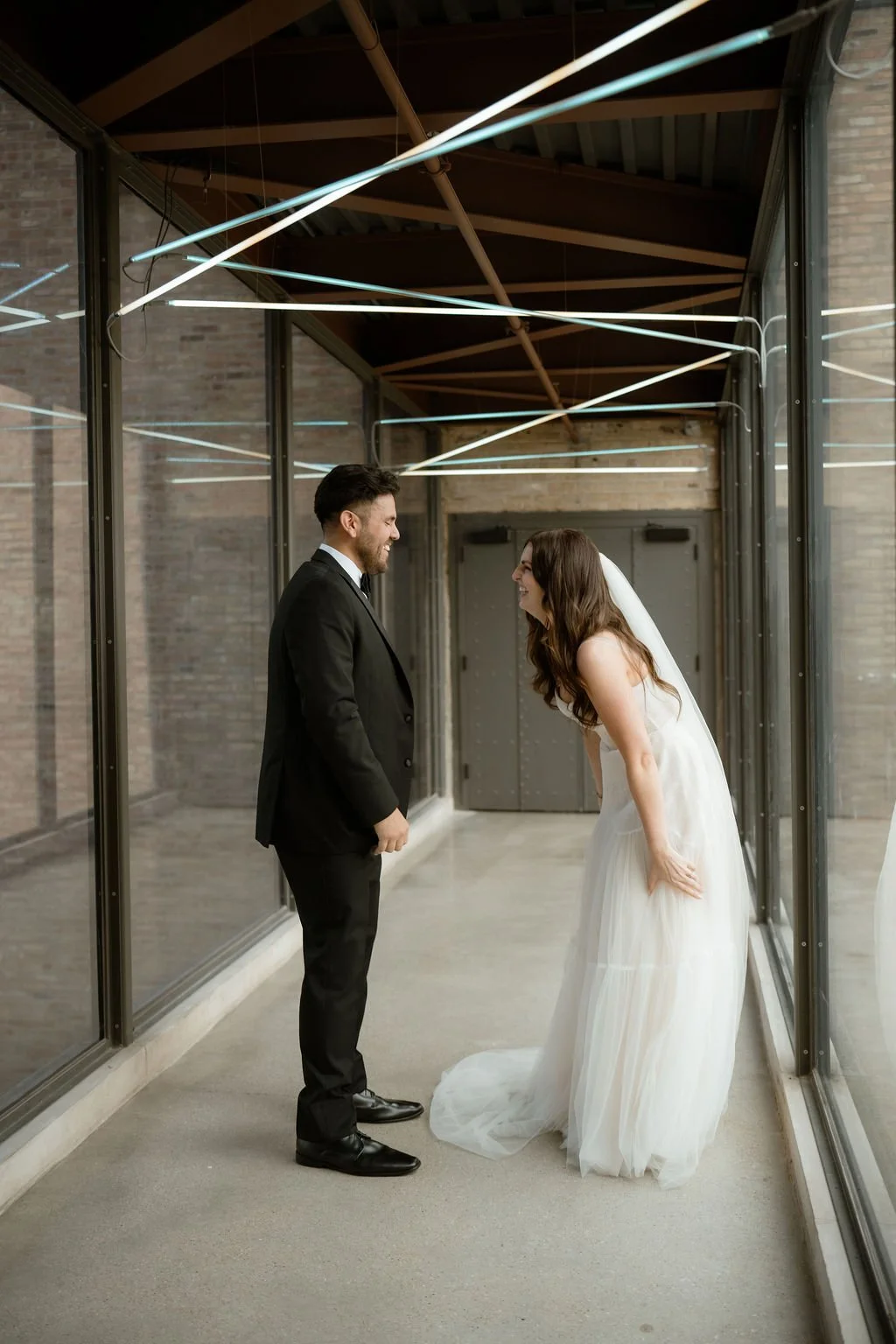 Chicago wedding bride and groom looking at each other for first look with bride bent over laughing