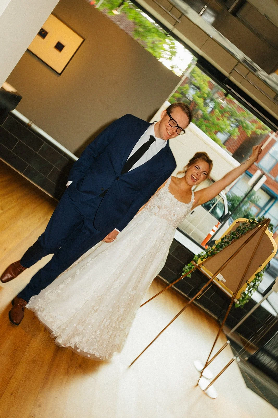 Couple grand entrance into wedding reception at Floating World Gallery in Chicago cheering and smiling