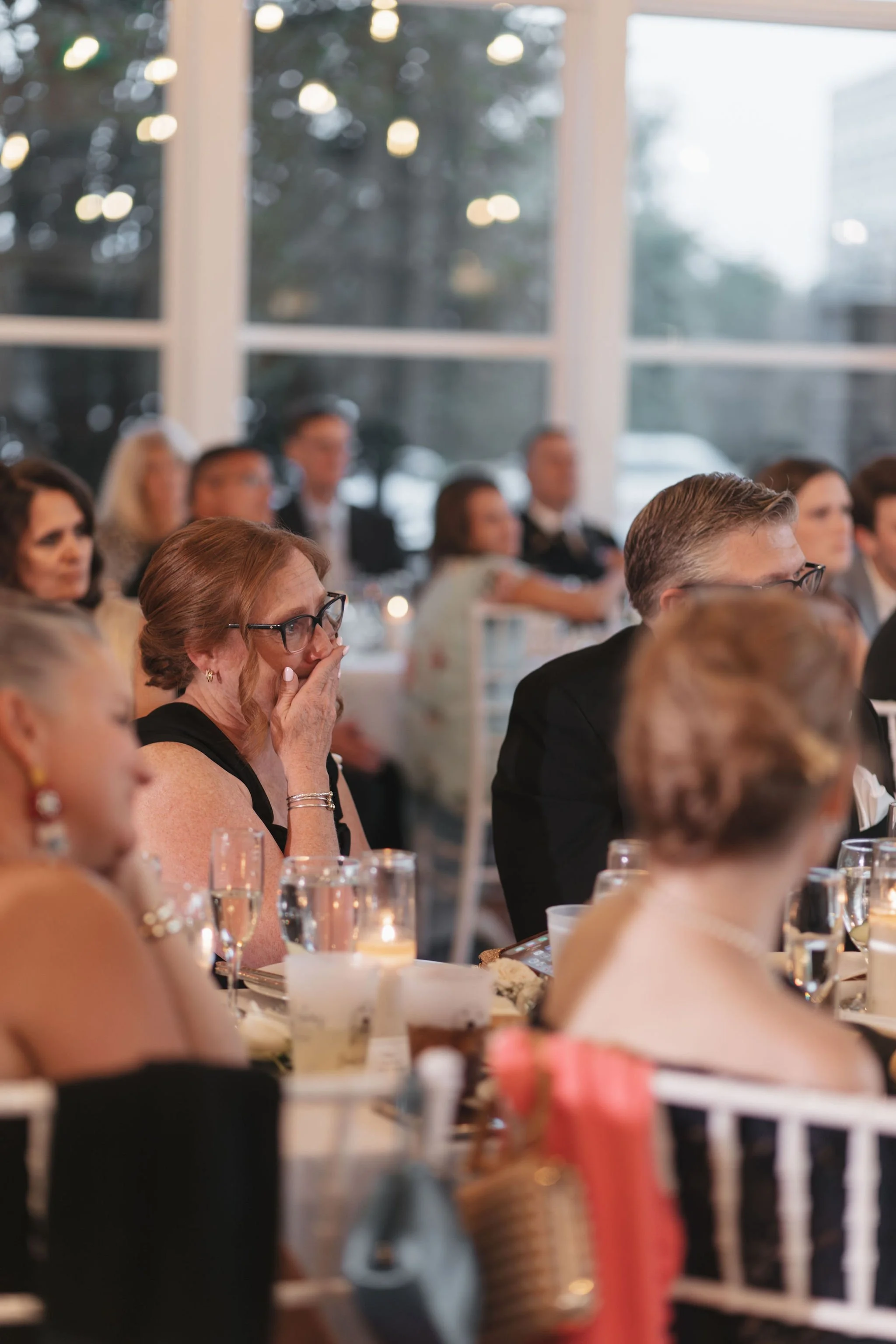 Mother of bride teary eyed holding hand in front of face