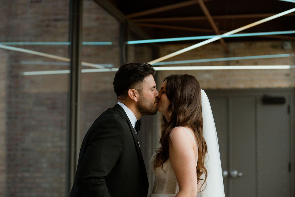 Bride and groom kissing at first look at Rockwell on the River in Chicago for wedding