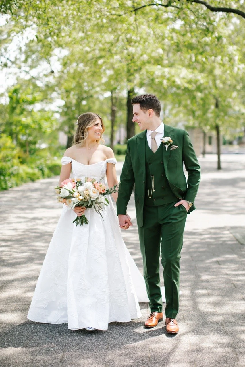 Bride and groom walking on paved road outdoors