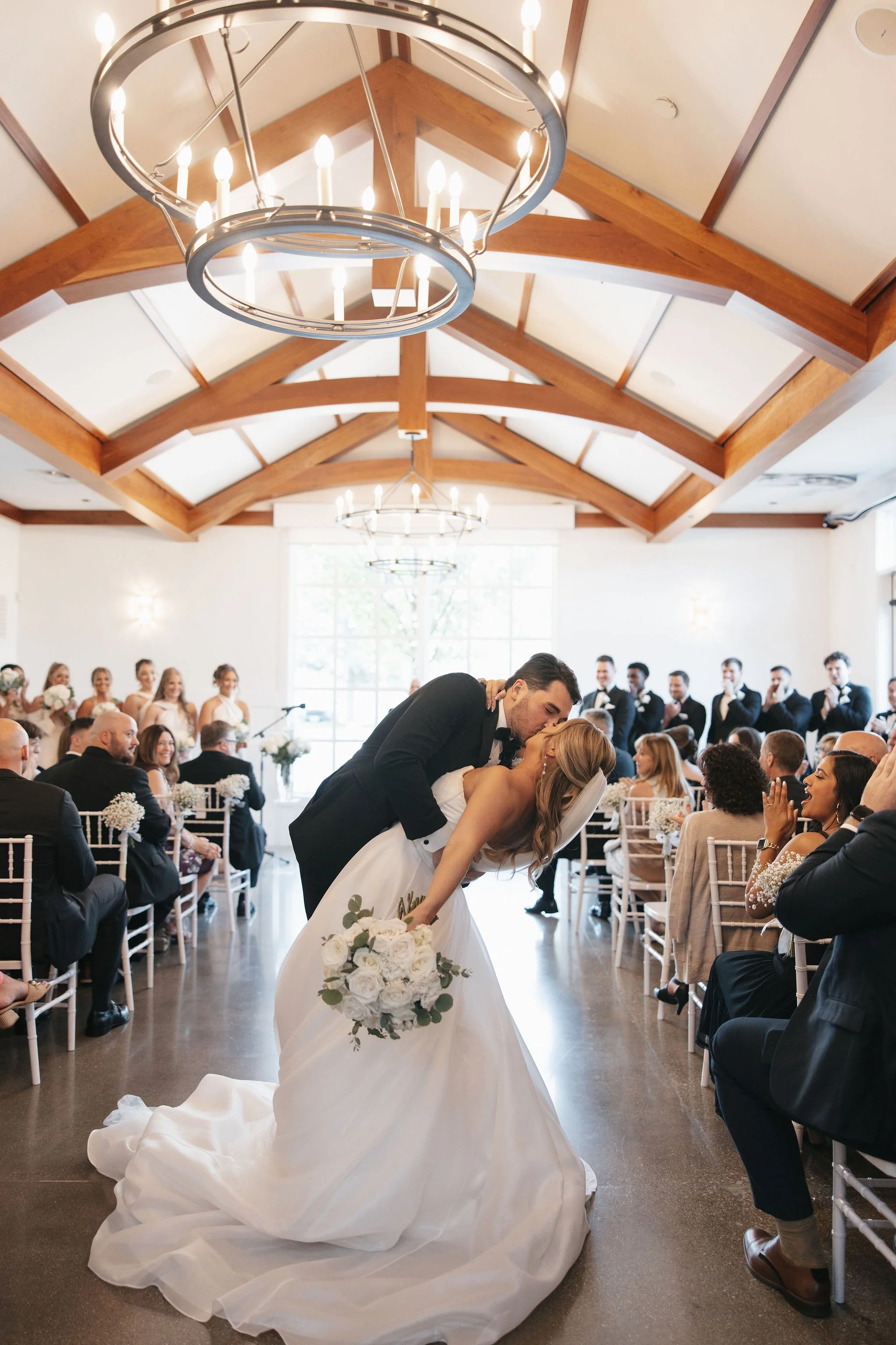 Bride and groom doing a dip kiss in aisle during wedding recessional after just getting married