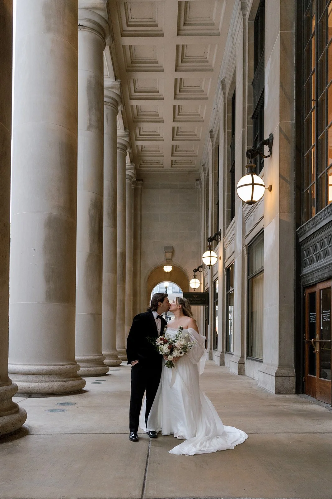 Zoomed out couple's photos kissing at Union Station in Chicago