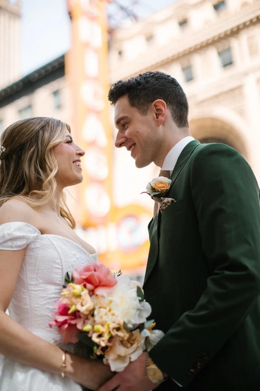Couple smiling at each other with Chicago Theatre sign in background