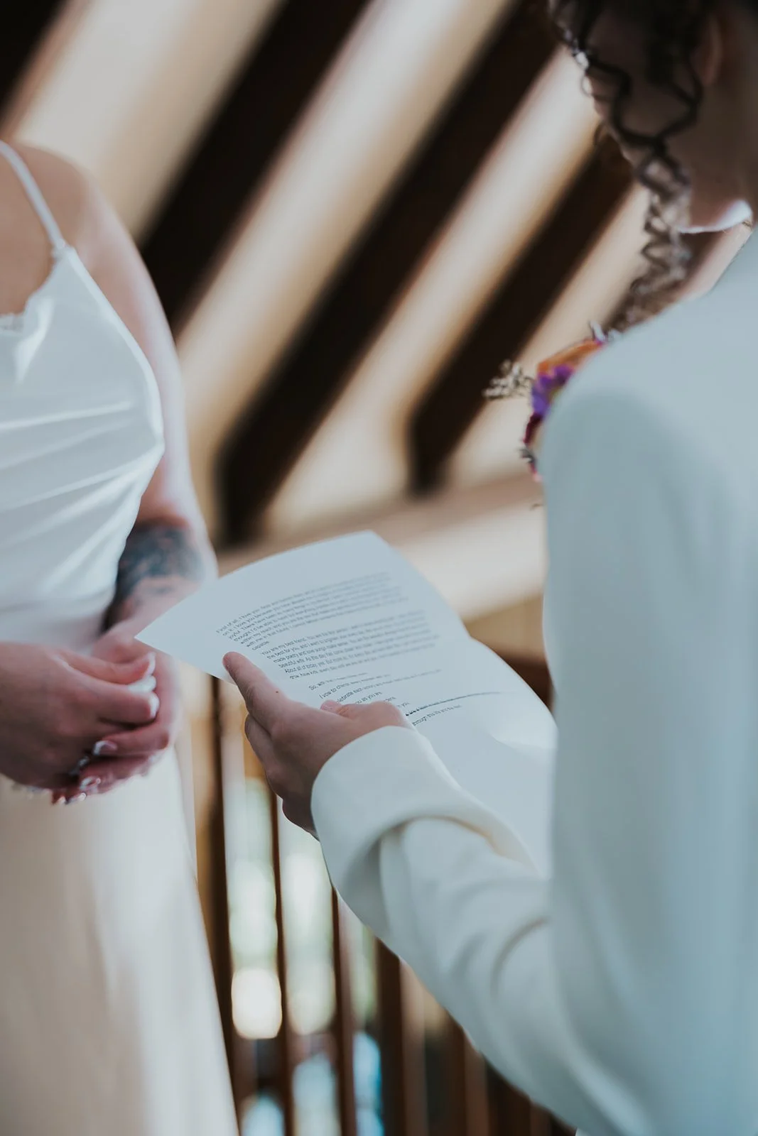 Two brides closeup of typed vows reading to each other