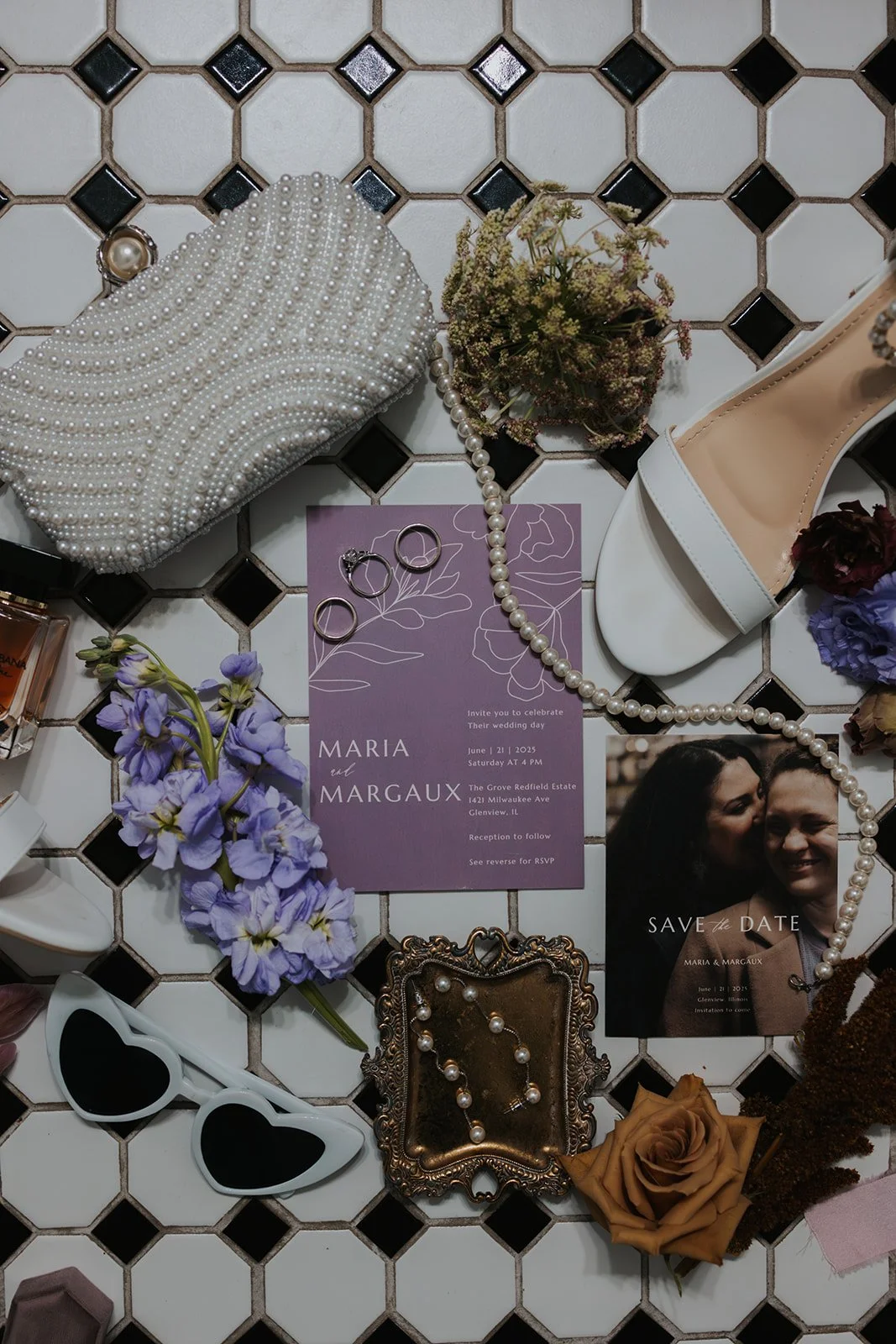 black and white mosaic tile floor with purse, flowers, rings, invitation, and jewelry all laid out
