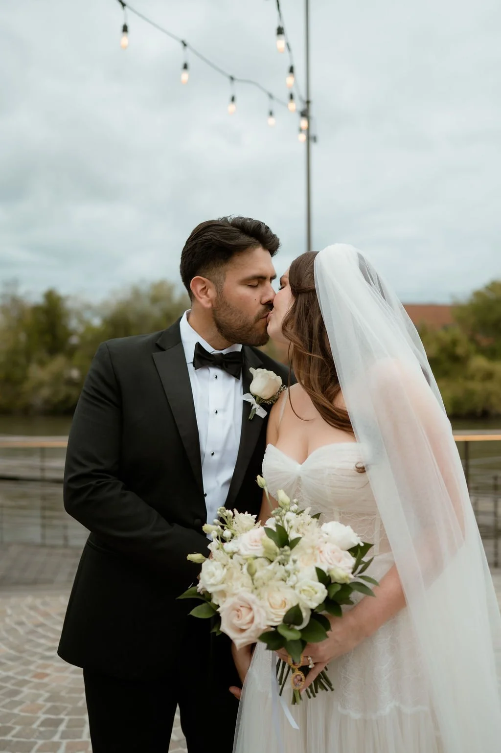 Bride and groom kissing outdoors for couple's portraits