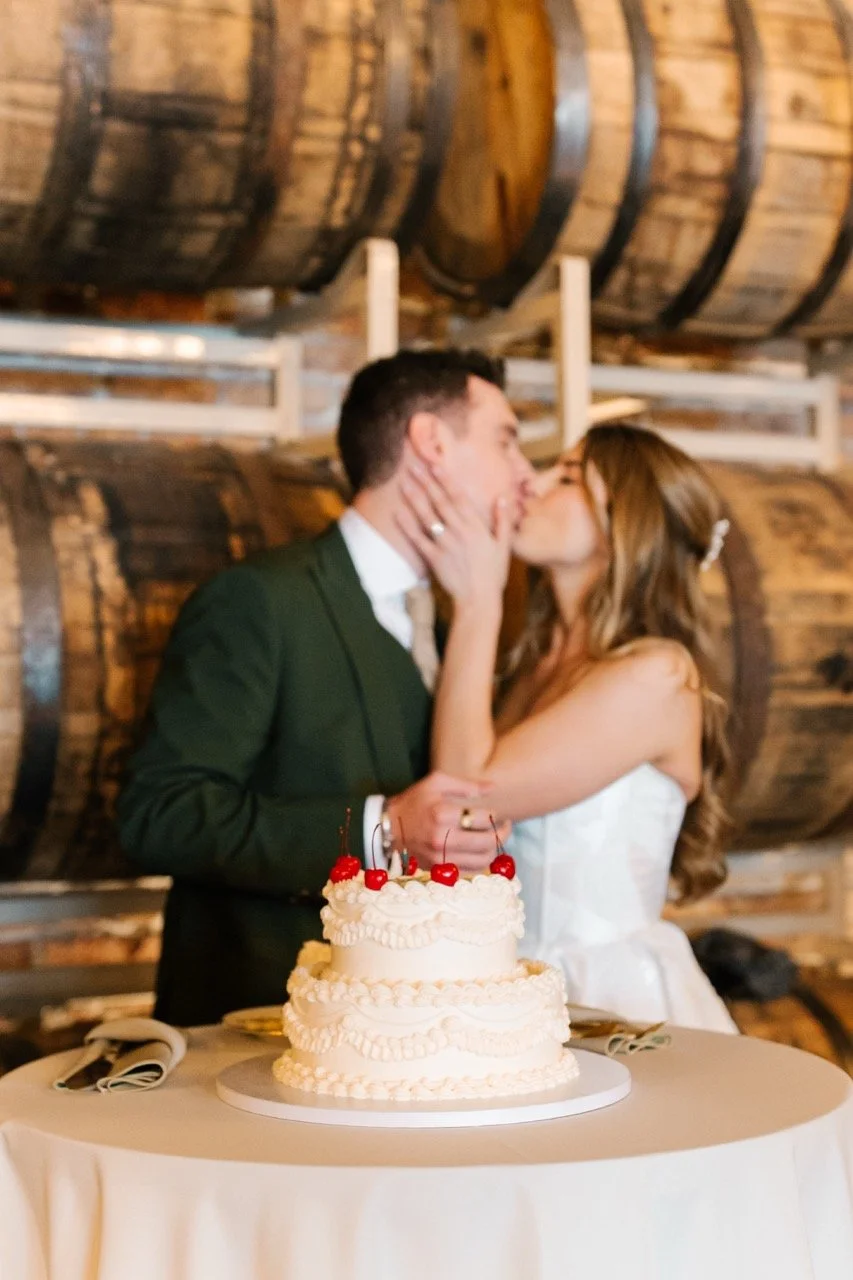 Vintage cake cut with couple kissing in background