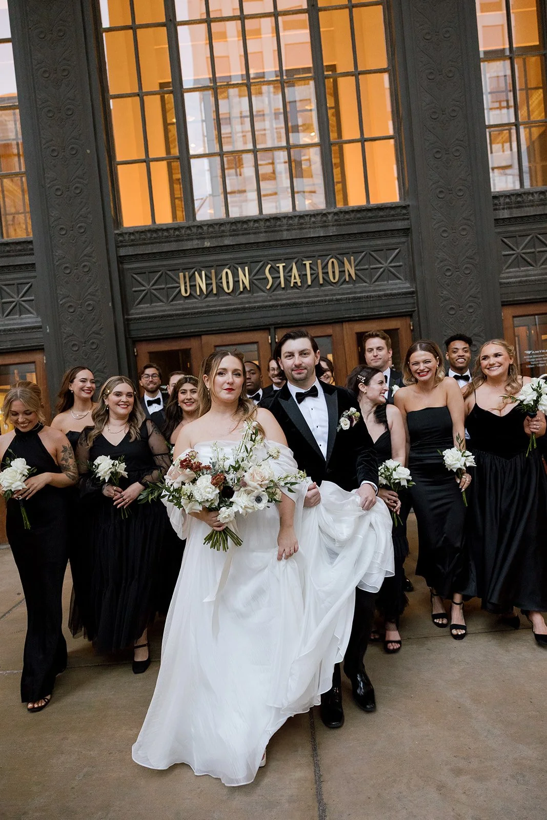 Couple and wedding party standing at door outside Union Station in Chicago