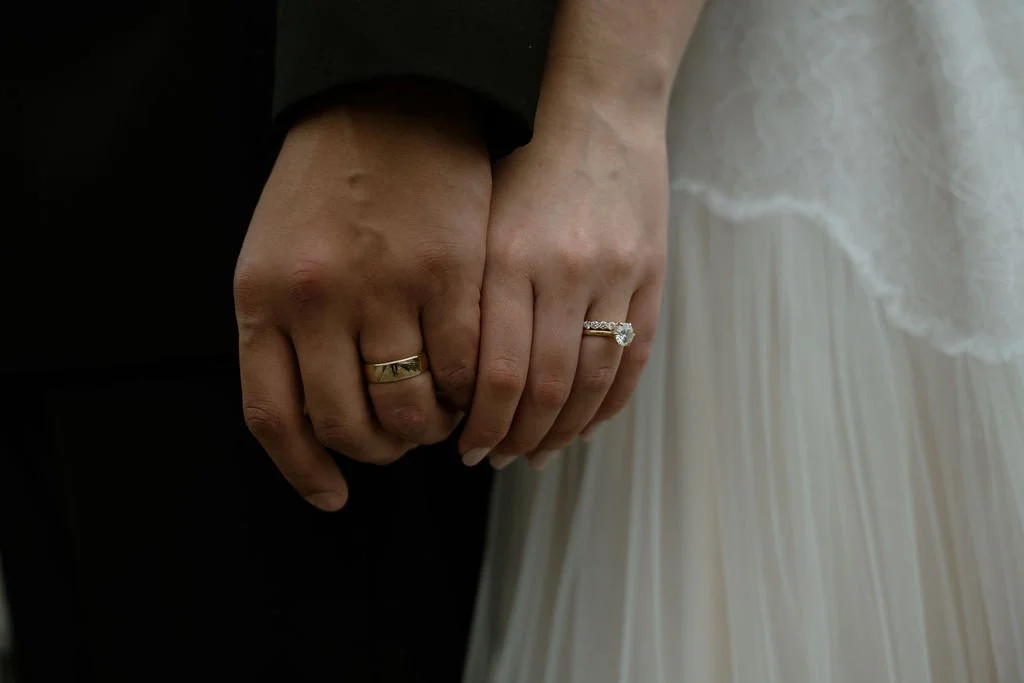 Bride and groom hands touching showing their wedding rings